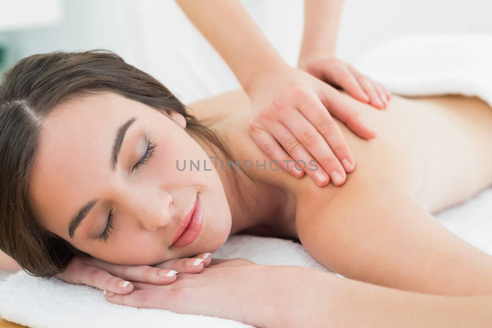 Close up of a beautiful woman enjoying back massage at beauty spa