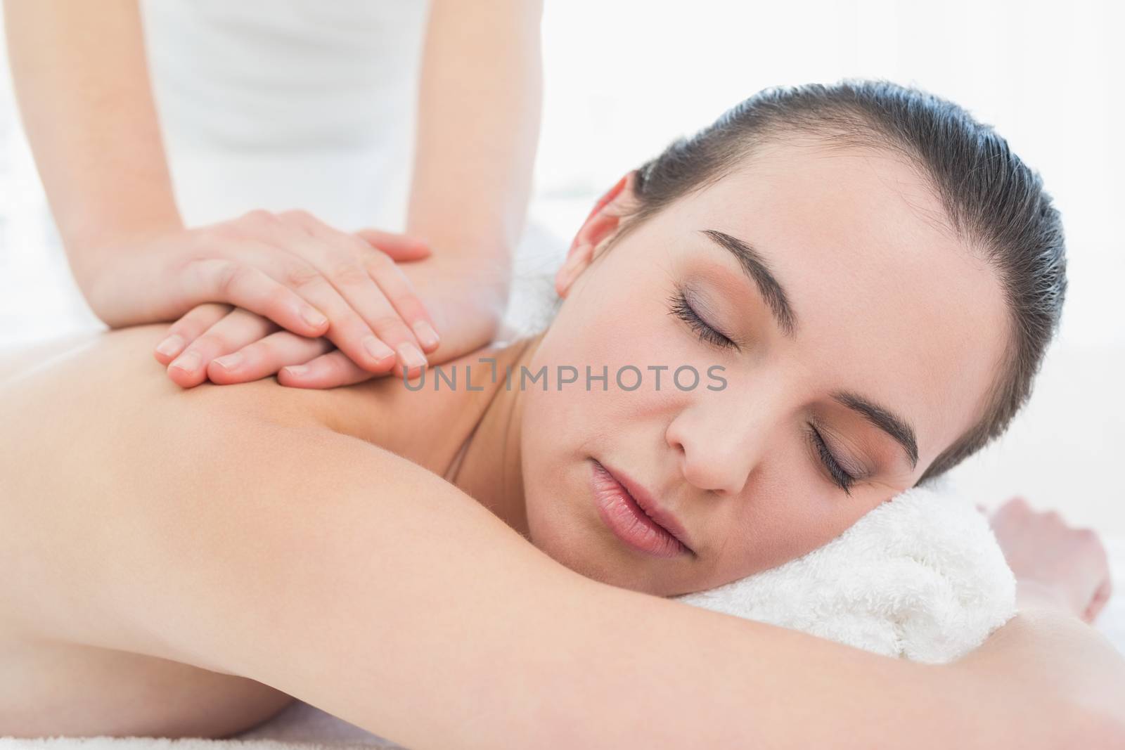 Close up of a beautiful woman enjoying back massage at beauty spa