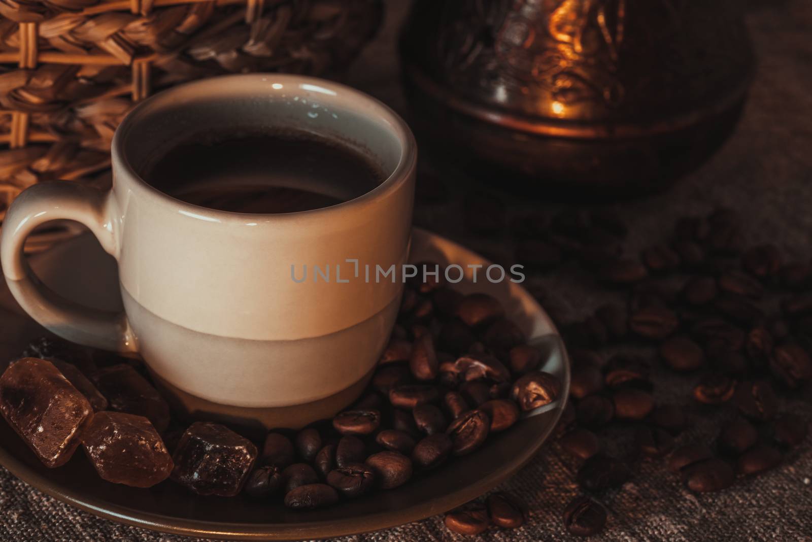 cup of coffee on textile with beans, dark candy sugar, pots, basket and cake by Seva_blsv