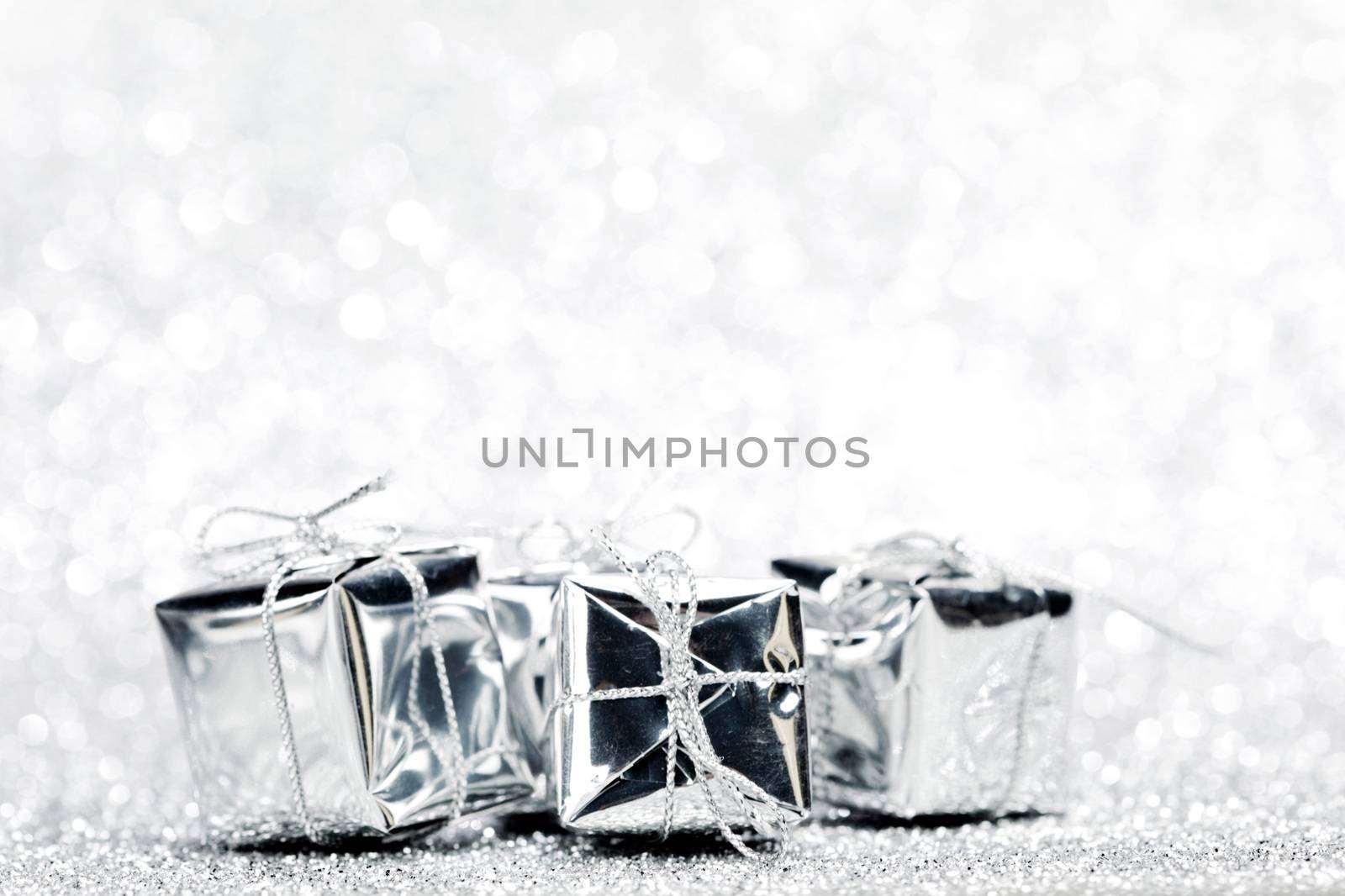 Decorated holiday gifts on silver background
