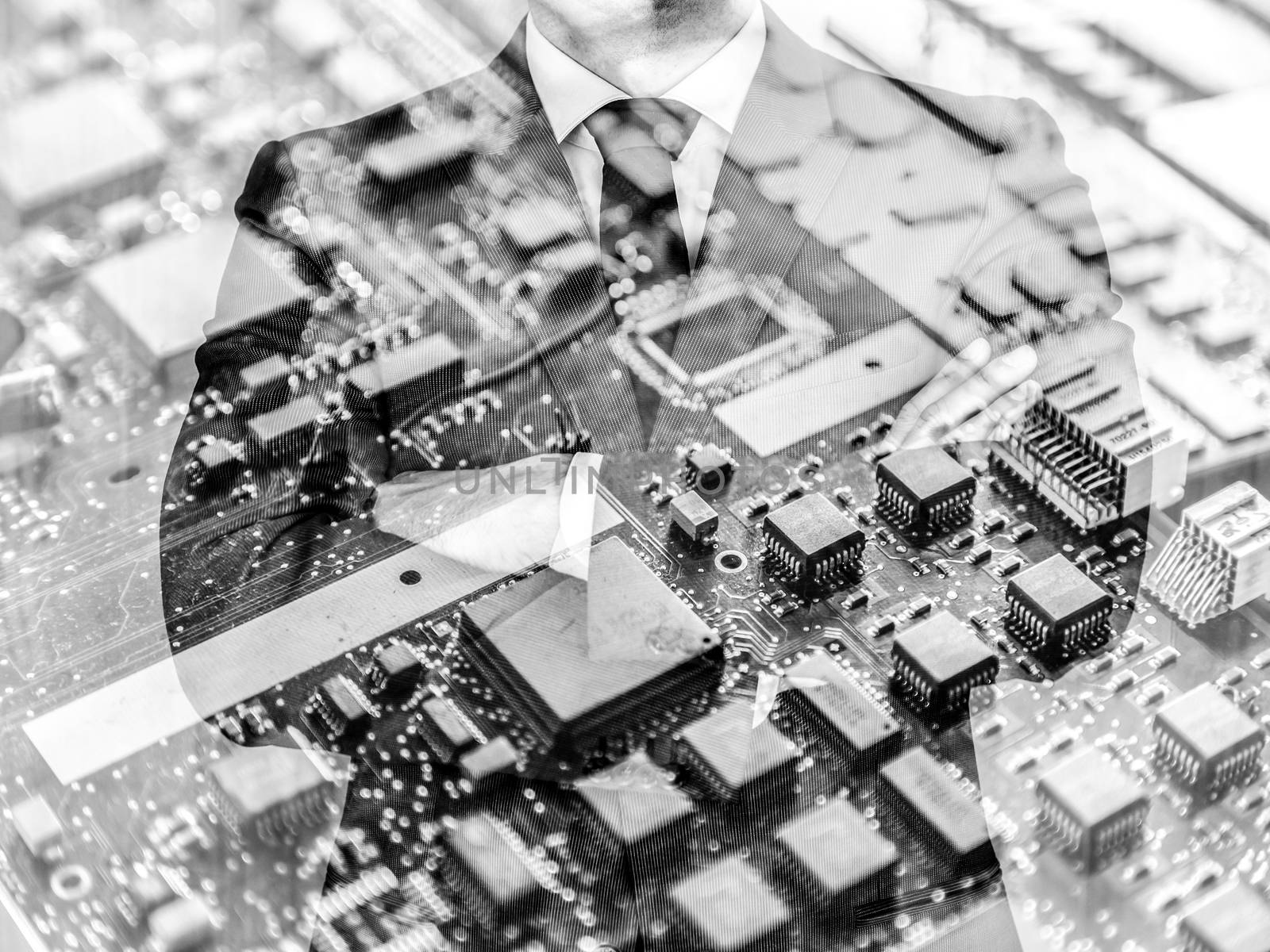 Businessman standing with folded arms in a classic navy blue suit against pc motherboard chip photo layer. by kasto