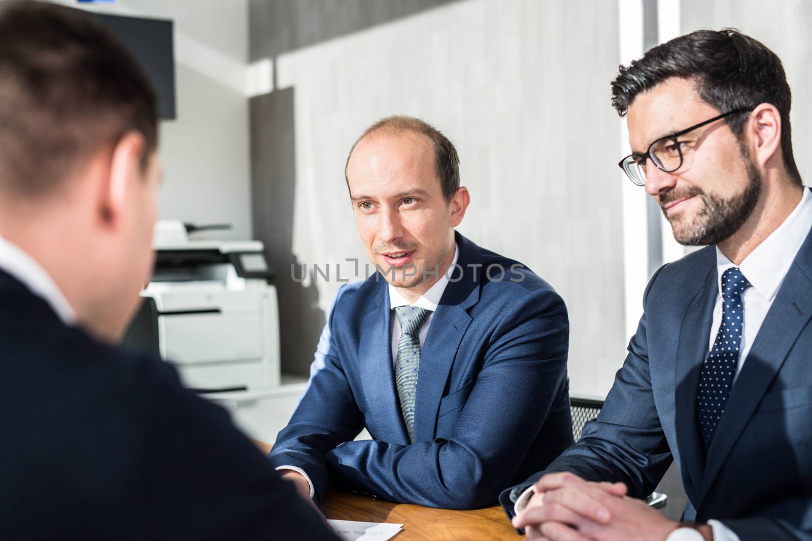 Team of confident successful business people discussing the contract terms at business meeting in modern corporate office. Business and entrepreneurship concept.