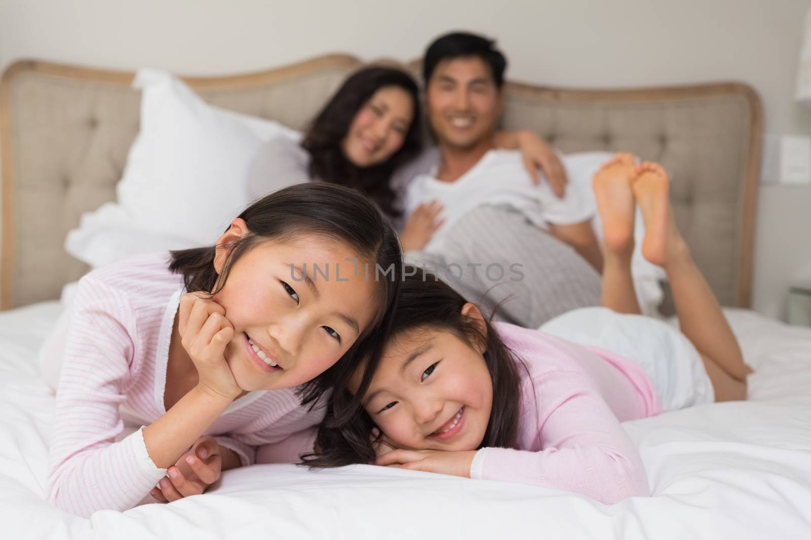 Kids with parents in bed at home by Wavebreakmedia