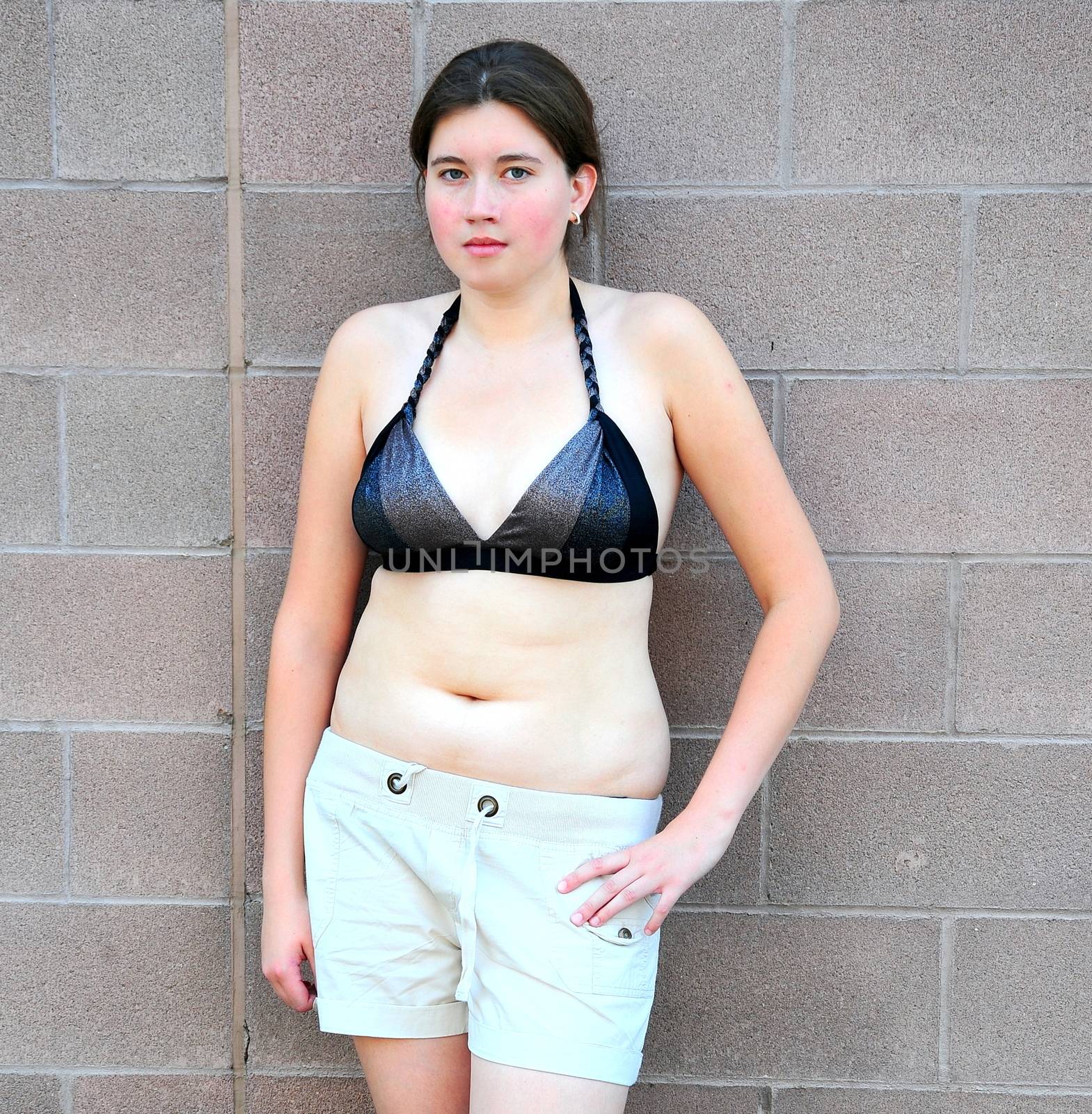 Female beauty fashion model expressions against a wall outside.