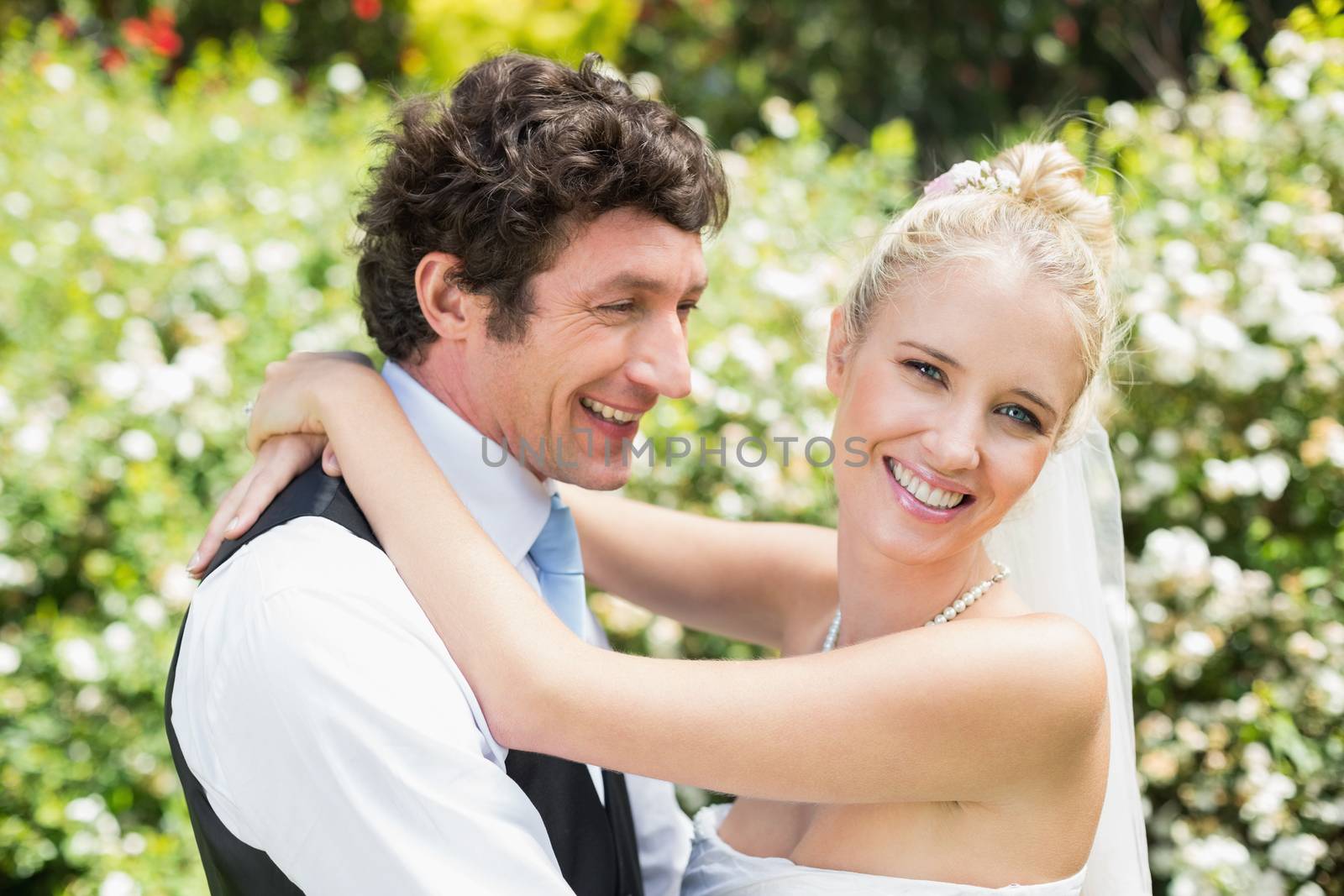 Romantic smiling newlywed couple hugging each other in the countryside