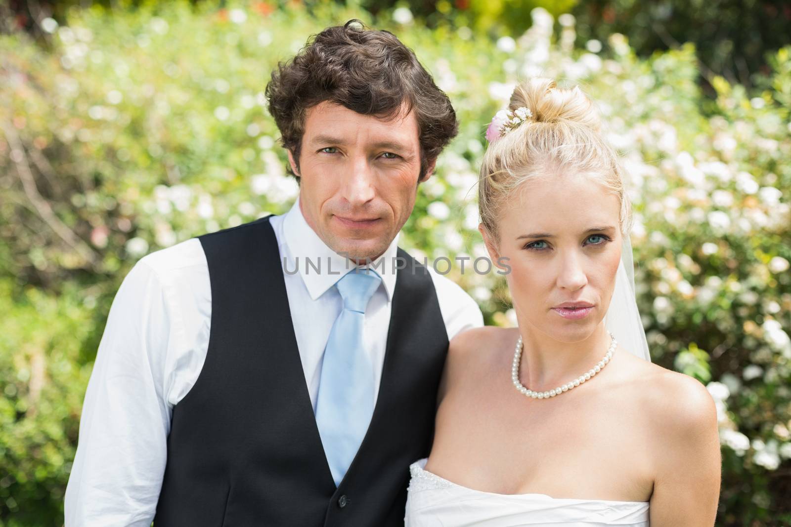 Romantic newlywed couple looking at camera in the countryside