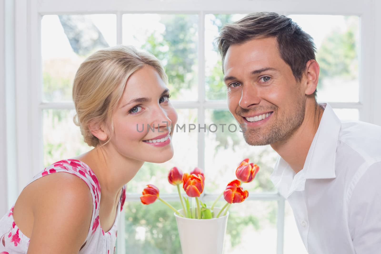 Side view portrait of a romantic young couple smiling at home