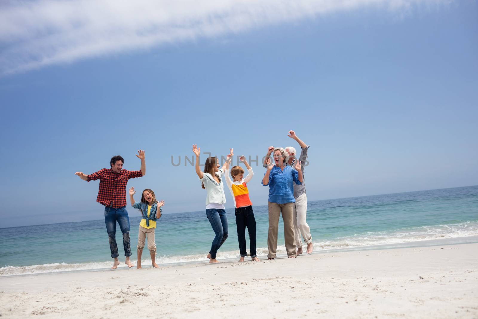 Family dancing on beach on a sunny day