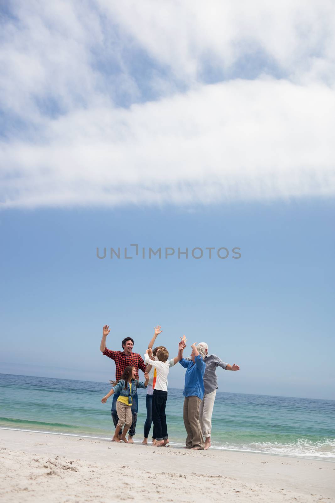 Portrait of happy family sitting on the beach on a sunny day