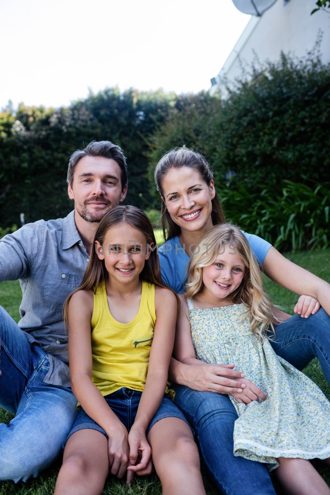 Portrait of happy family sitting together in a garden