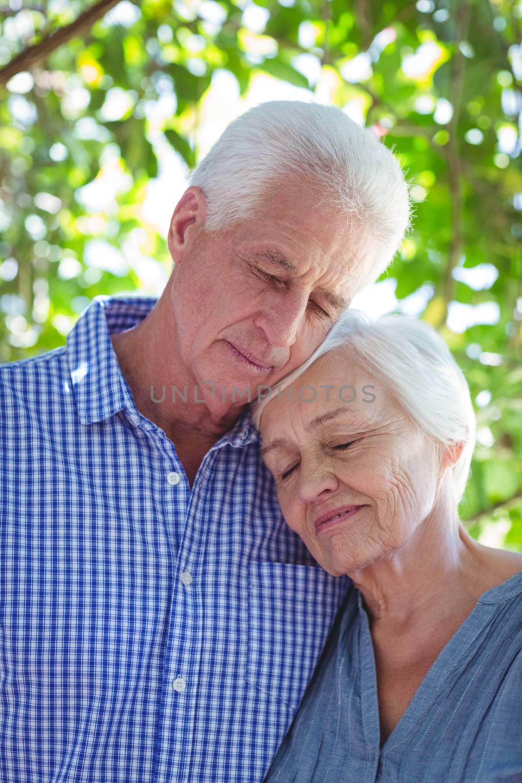 Senior couple with eyes closed while standing outdoors