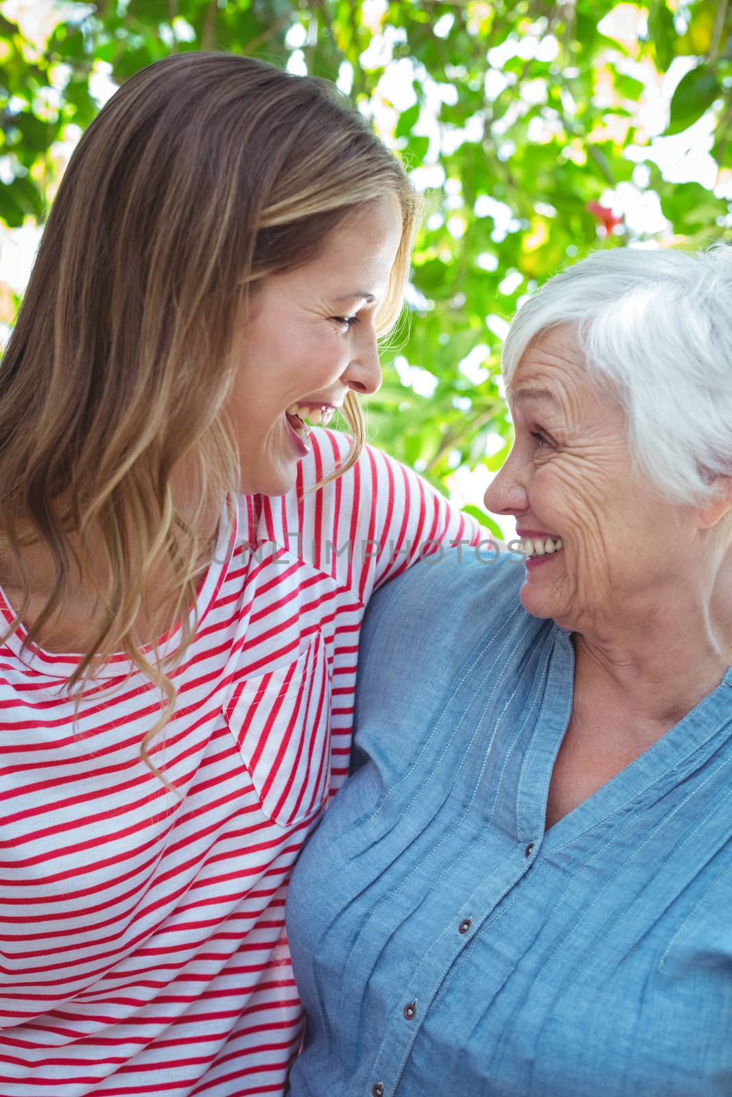 Cheerful mother and daughter with arm around  by Wavebreakmedia