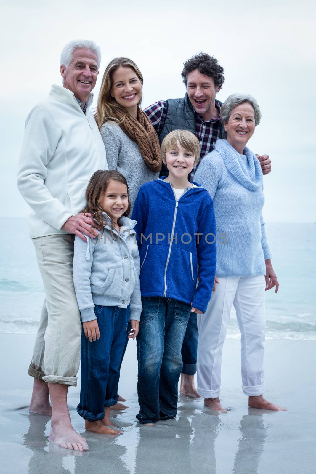 Happy family standing at beach by Wavebreakmedia