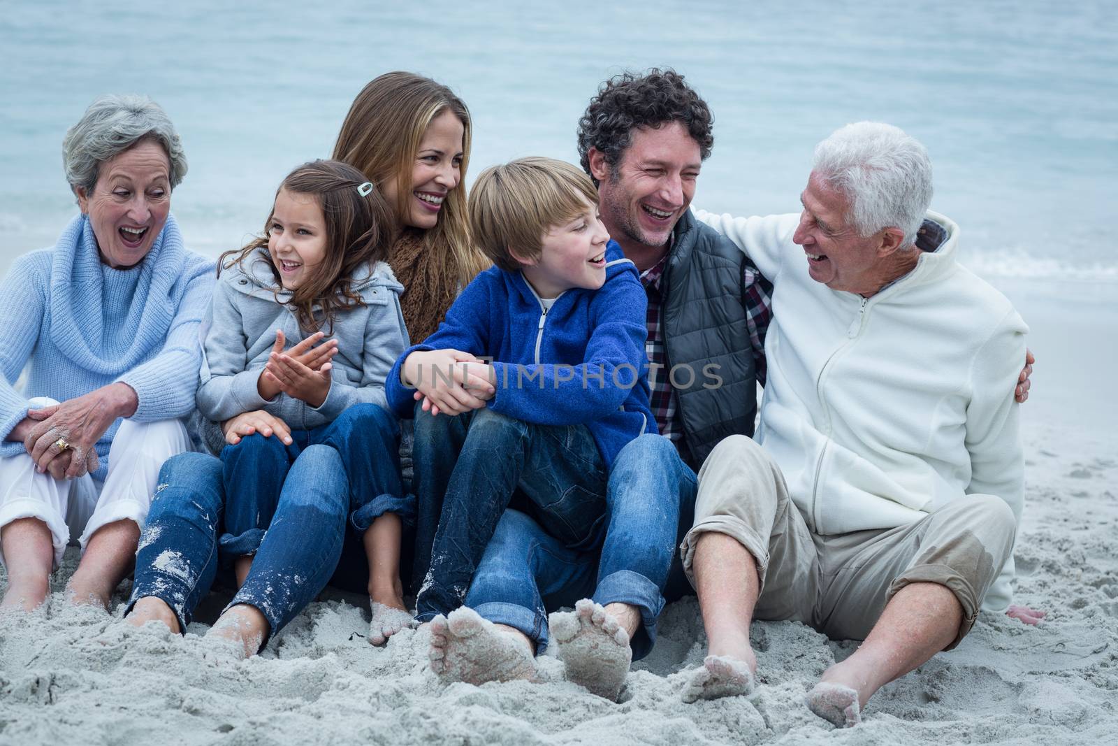 Family sitting at beach by Wavebreakmedia