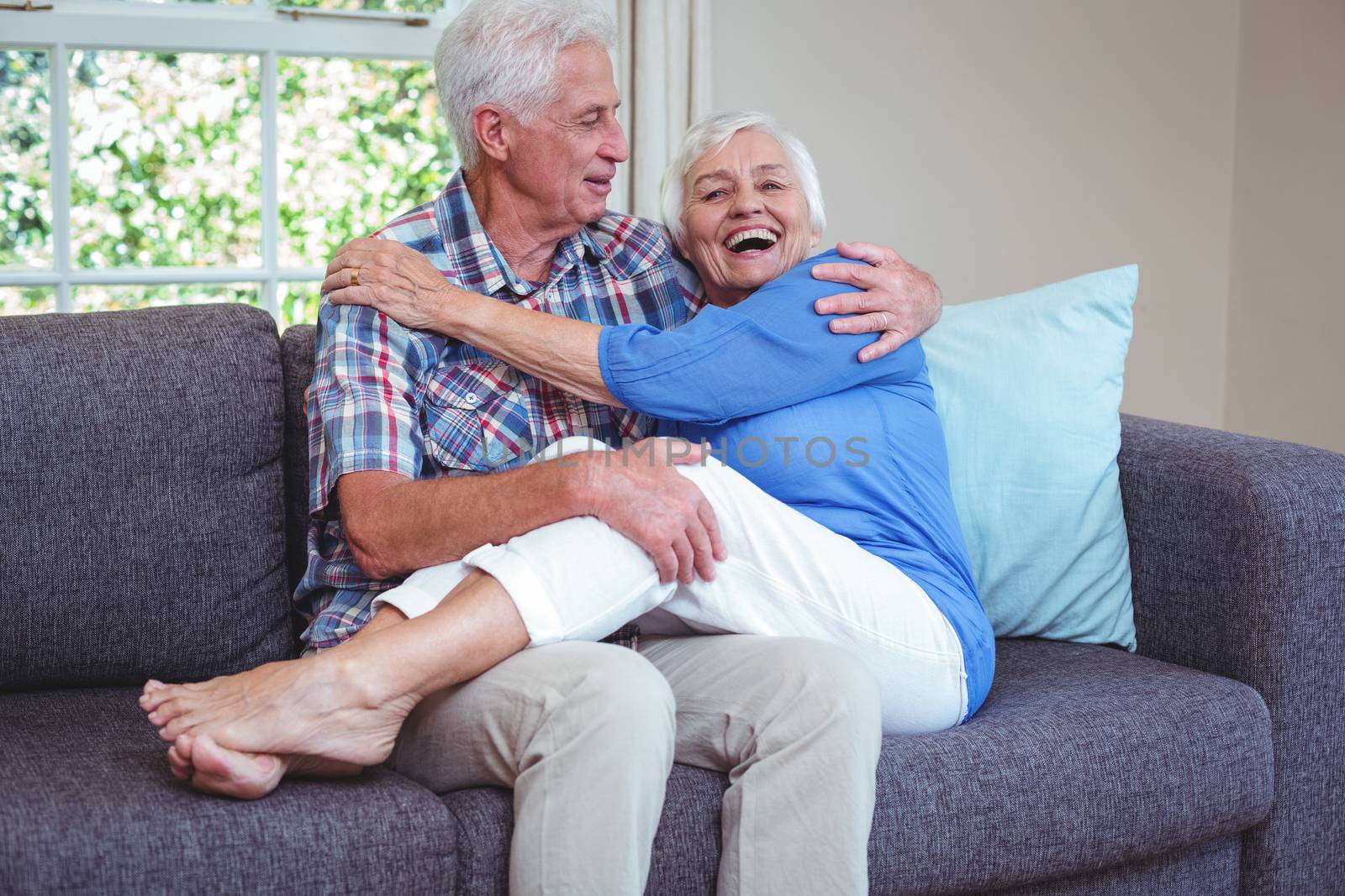Romantic senior couple sitting on sofa in living room