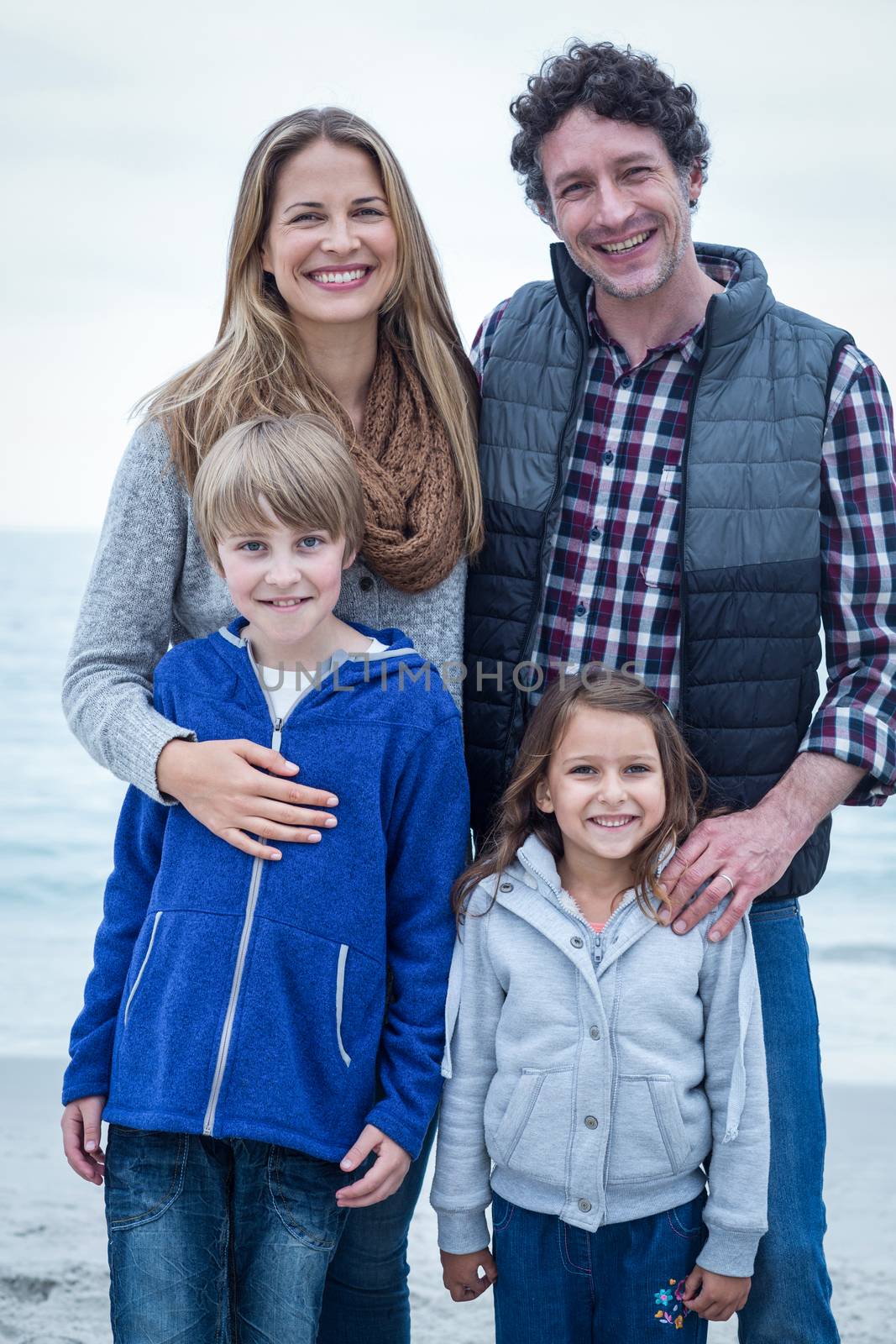 Portrait of happy family standing at sea shore