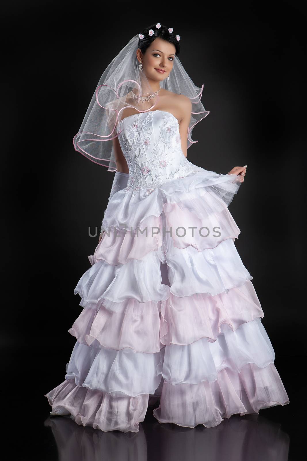 Young beautiful woman in a wedding dress on a studio background