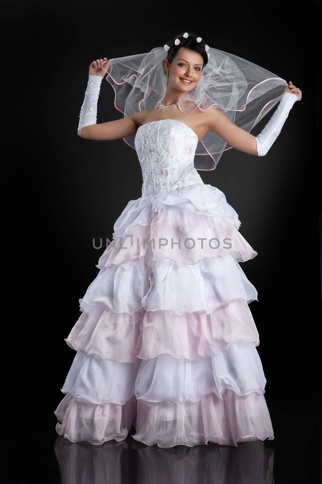 Young beautiful woman in a wedding dress on a studio background