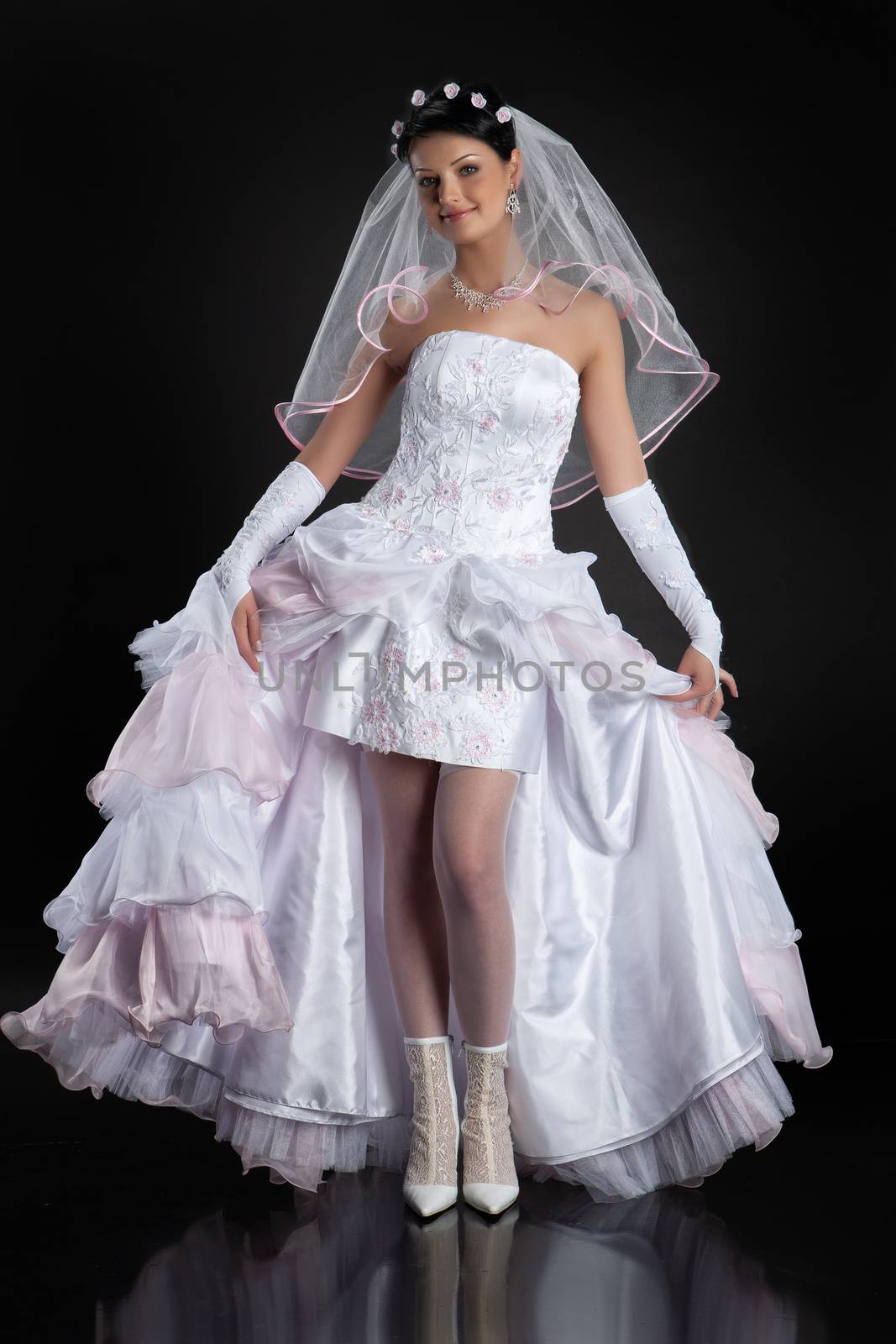 Young beautiful woman in a wedding dress on a studio background