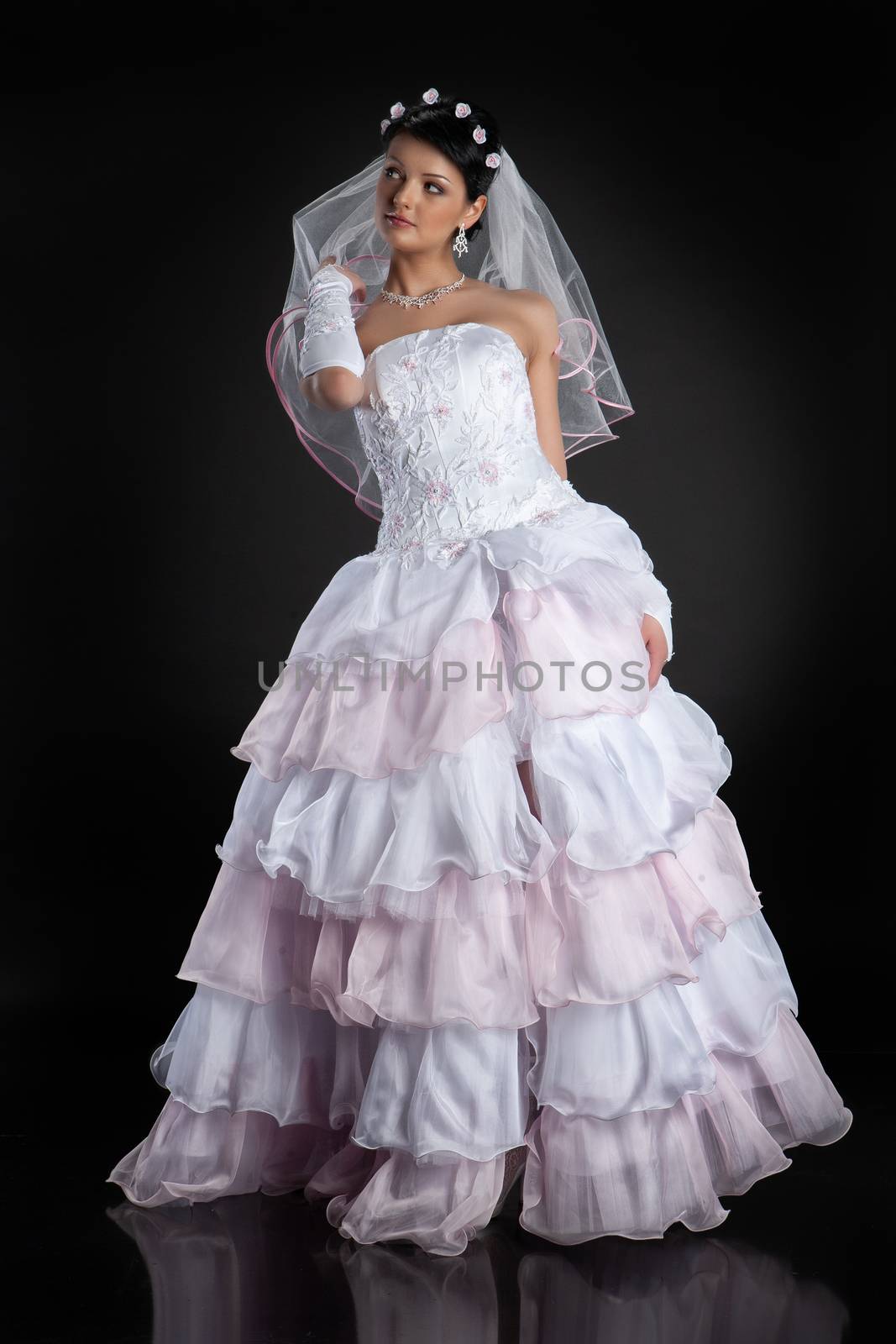 Young beautiful woman in a wedding dress on a studio background