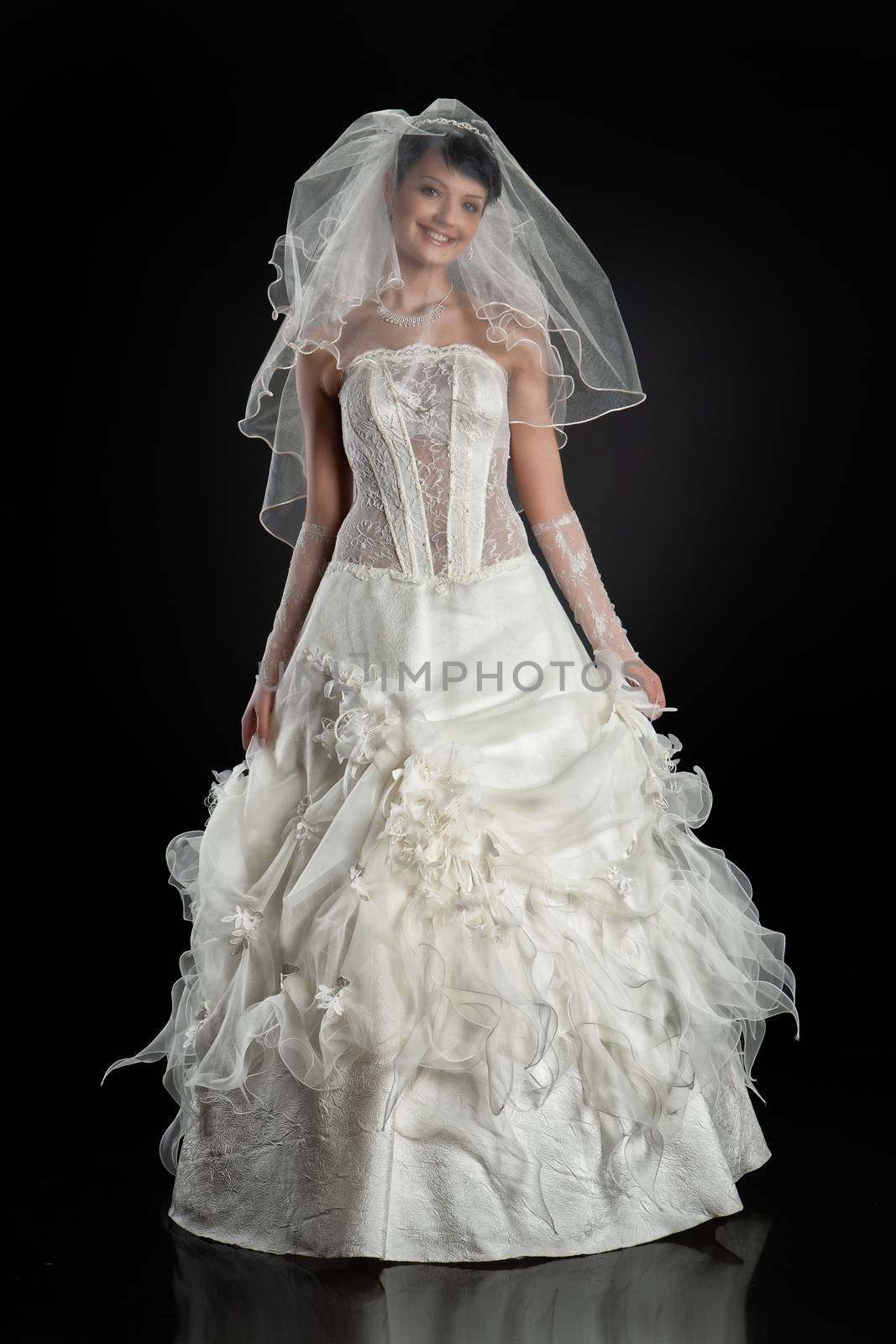 Young beautiful woman in a wedding dress on a studio background