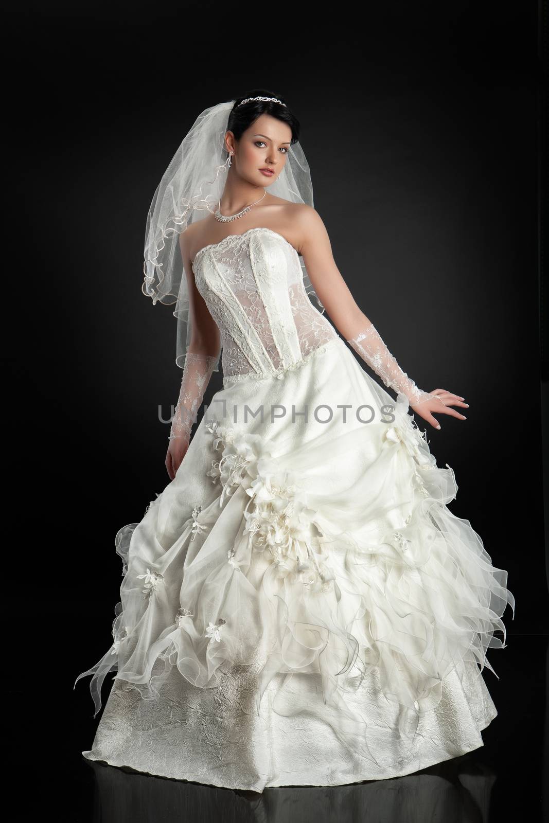 Young beautiful woman in a wedding dress on a studio background