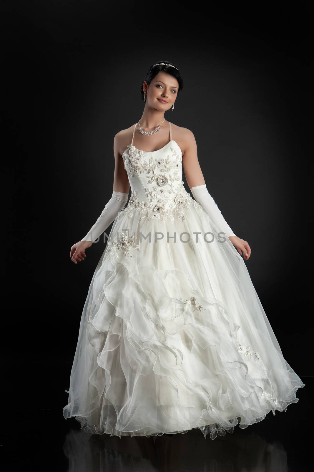 Young beautiful woman in a wedding dress on a studio background
