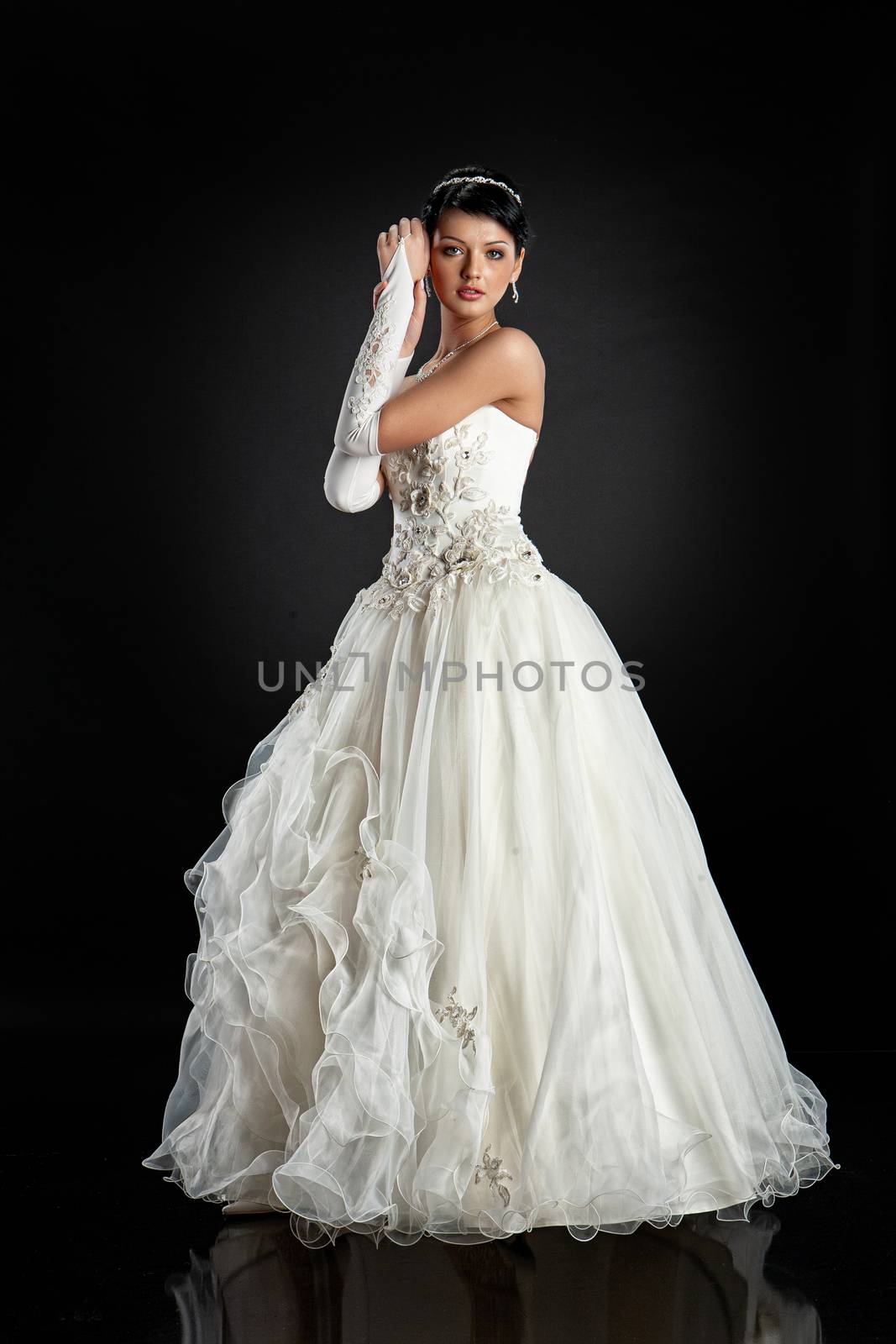 Young beautiful woman in a wedding dress on a studio background