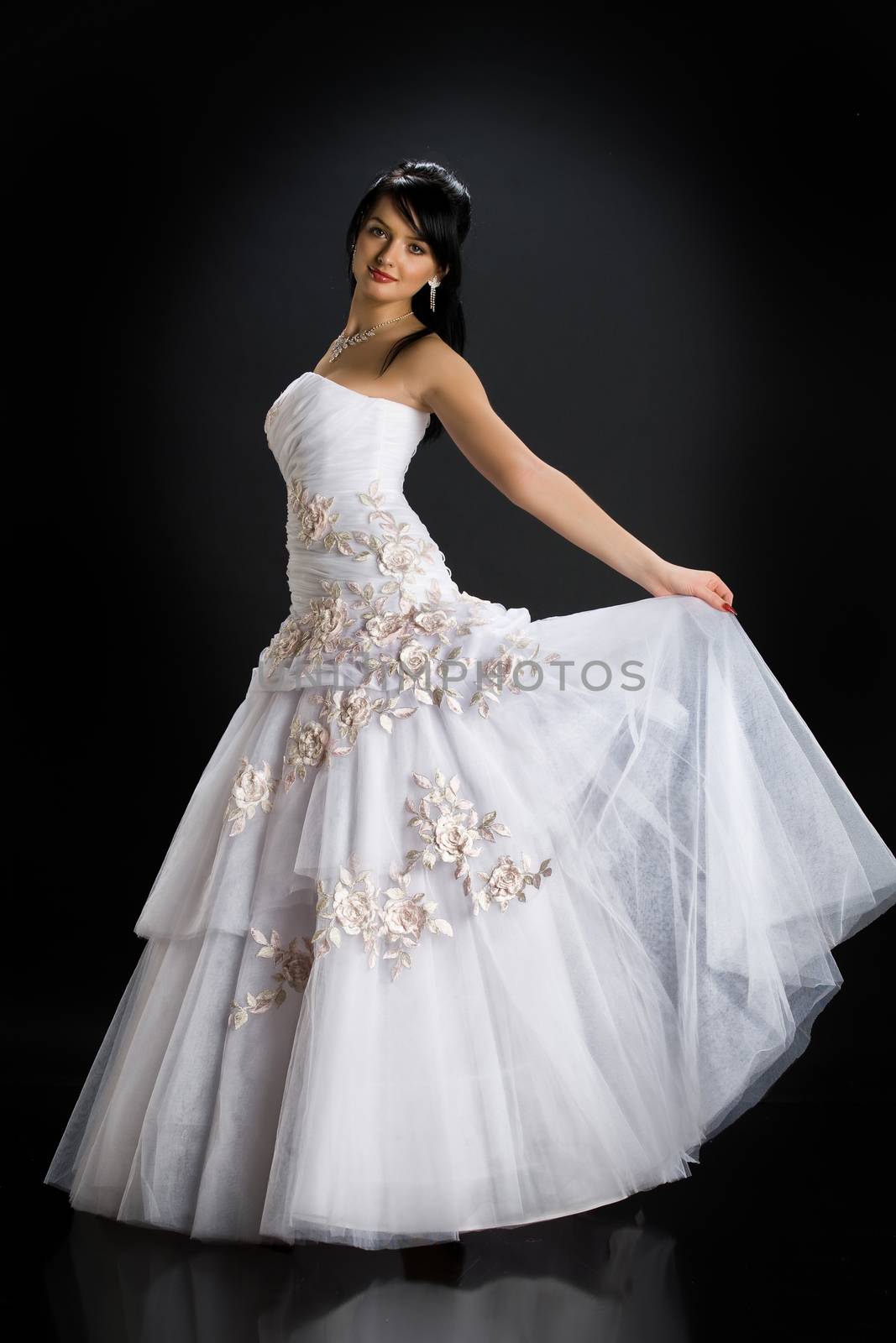 Young beautiful woman in a wedding dress on a studio background