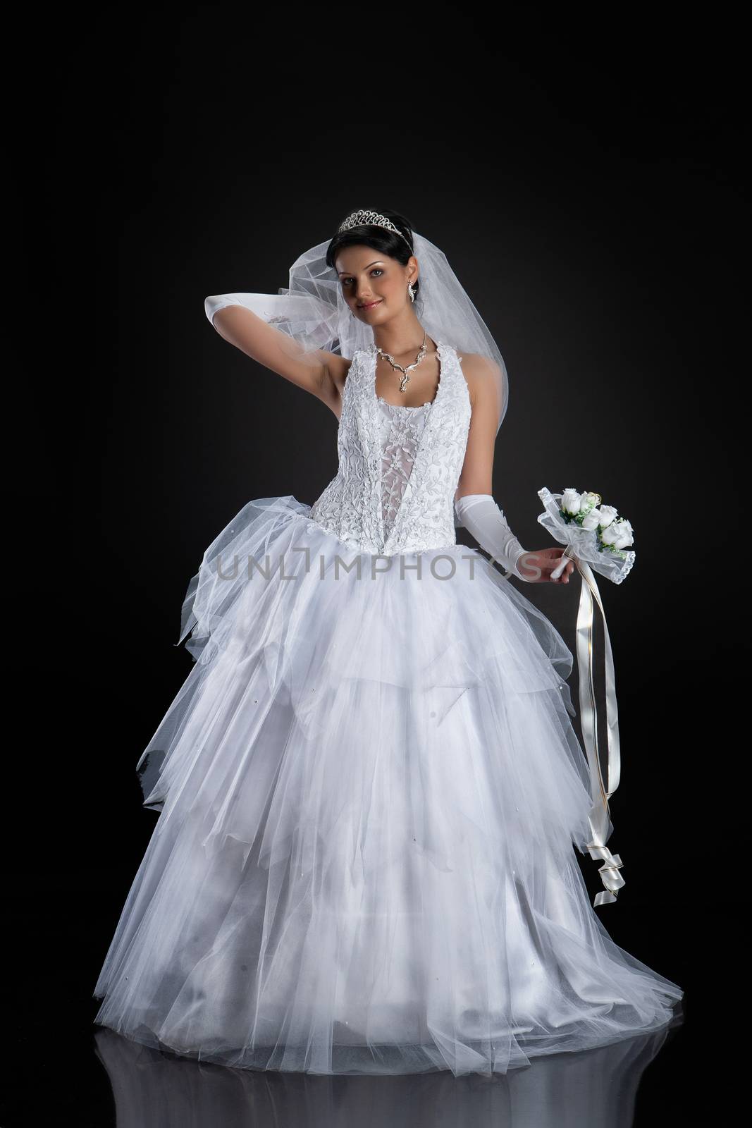 Young beautiful woman in a wedding dress on a studio background