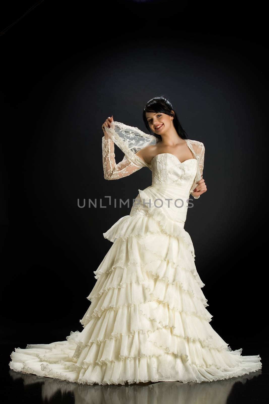 Young beautiful woman in a wedding dress on a studio background