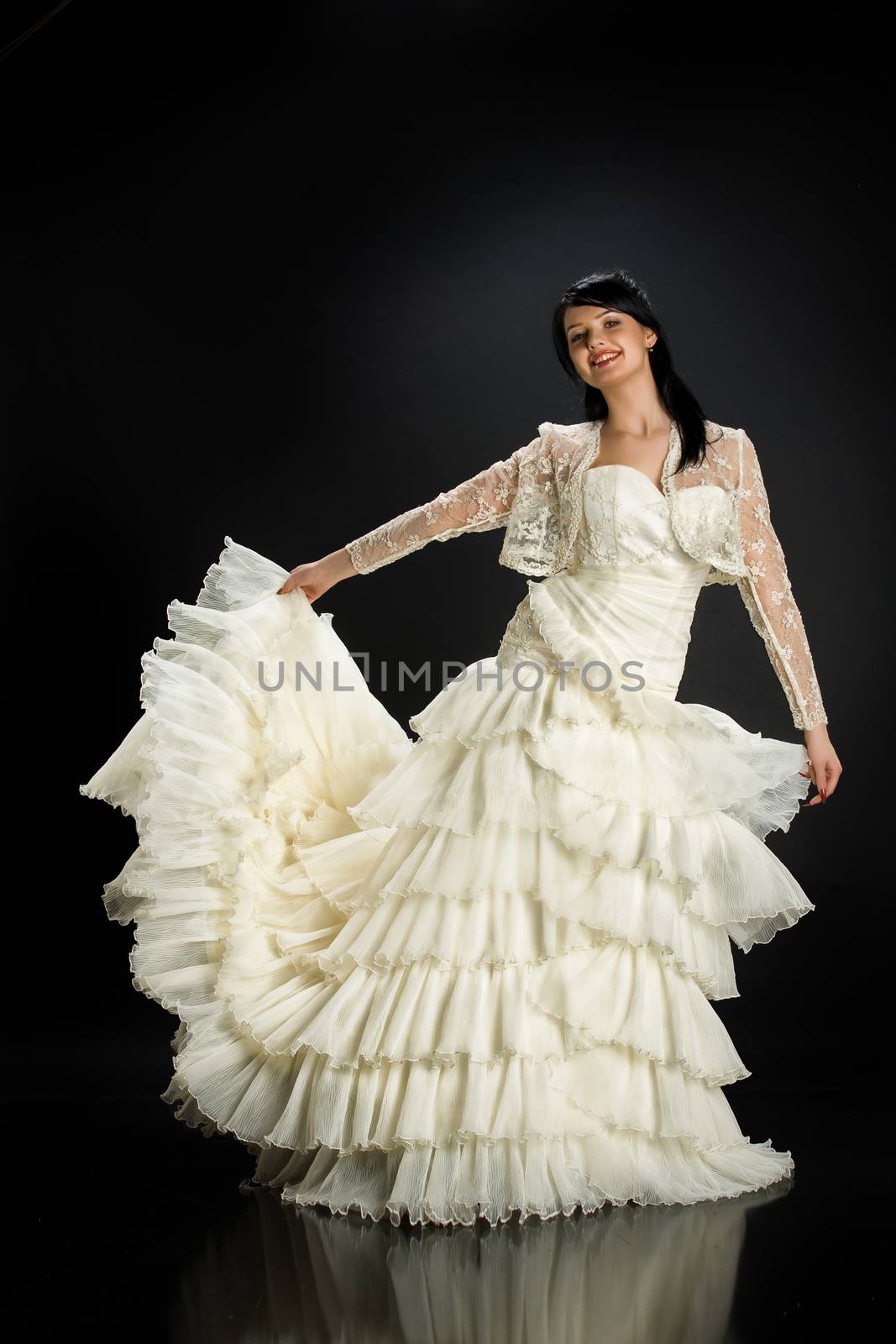 Young beautiful woman in a wedding dress on a studio background