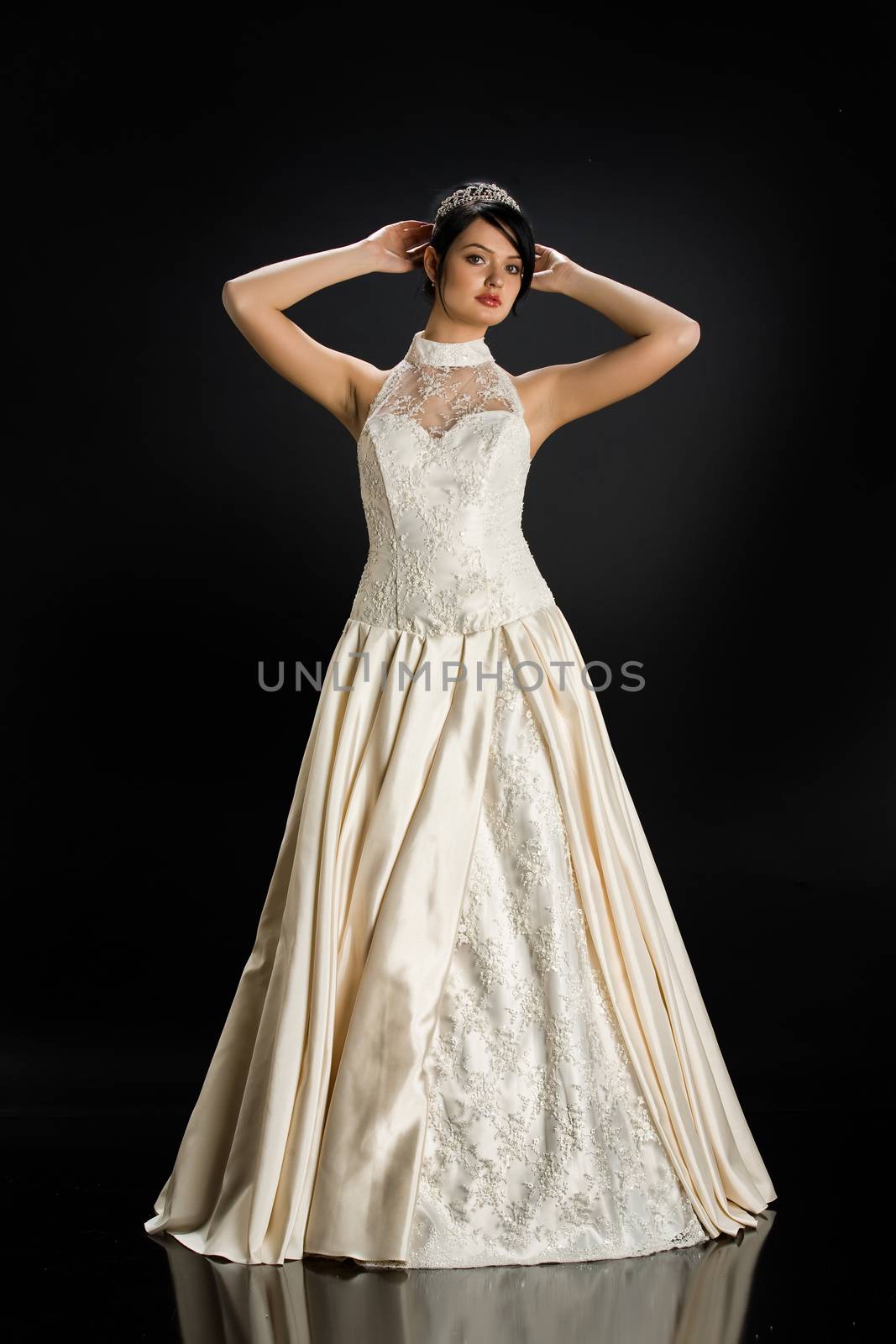 Young beautiful woman in a wedding dress on a studio background