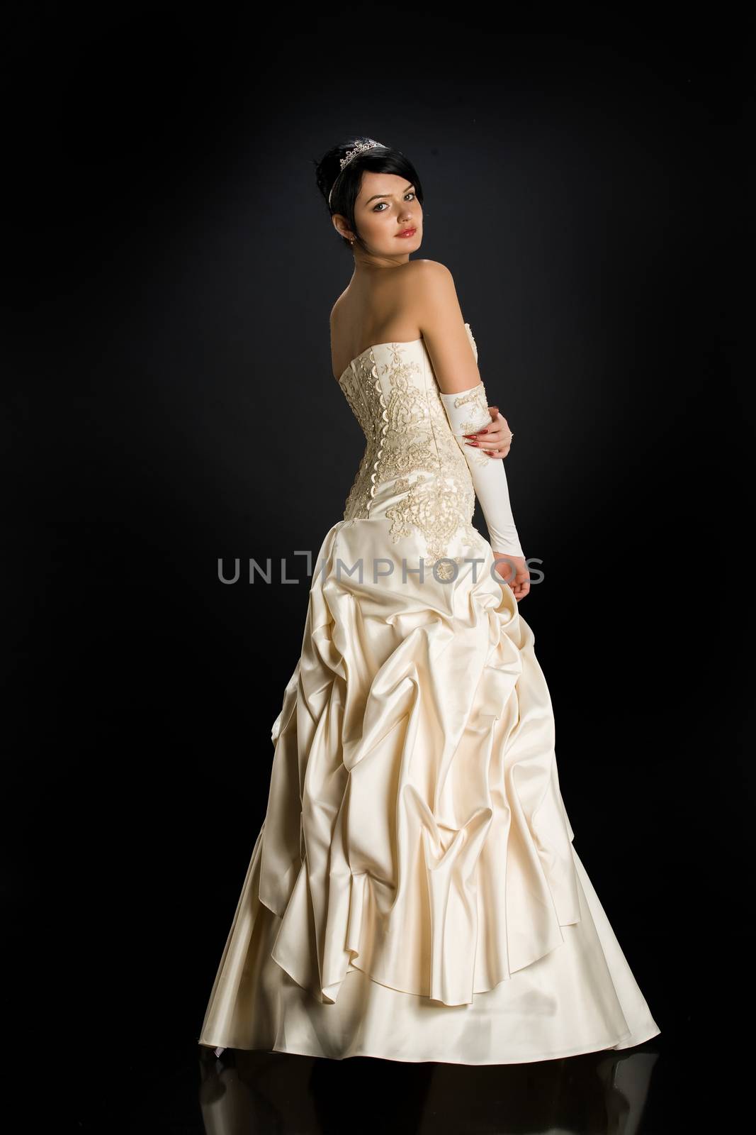 Young beautiful woman in a wedding dress on a studio background