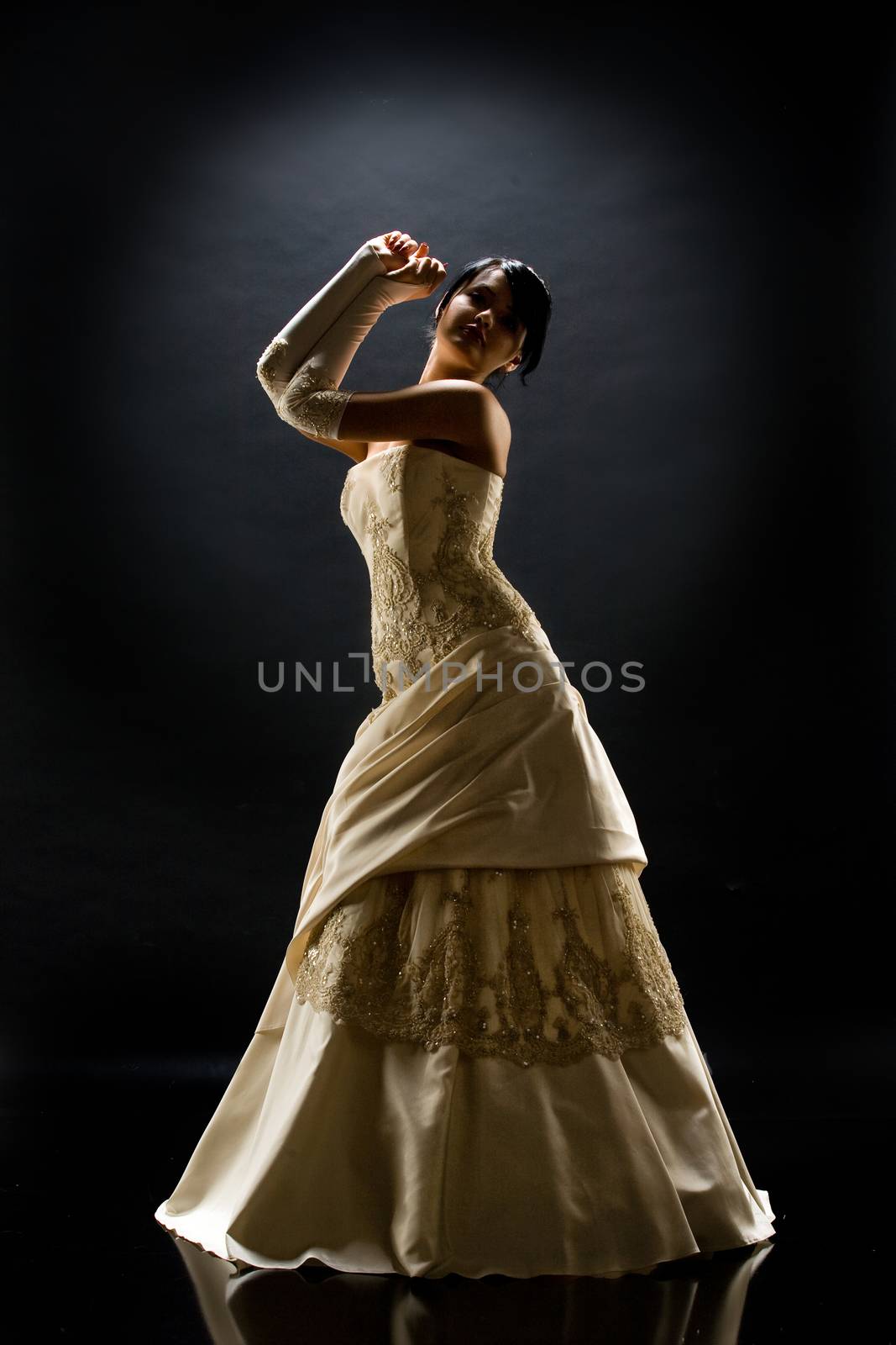 Young beautiful woman in a wedding dress on a studio background