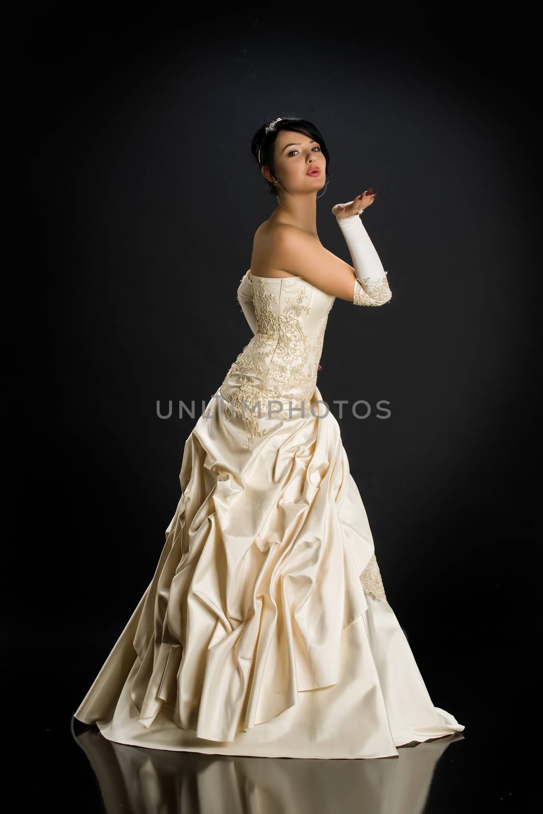 Young beautiful woman in a wedding dress on a studio background