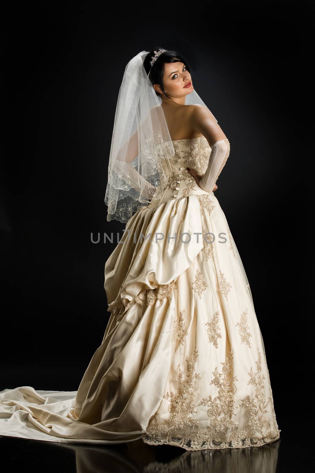 Young beautiful woman in a wedding dress on a studio background