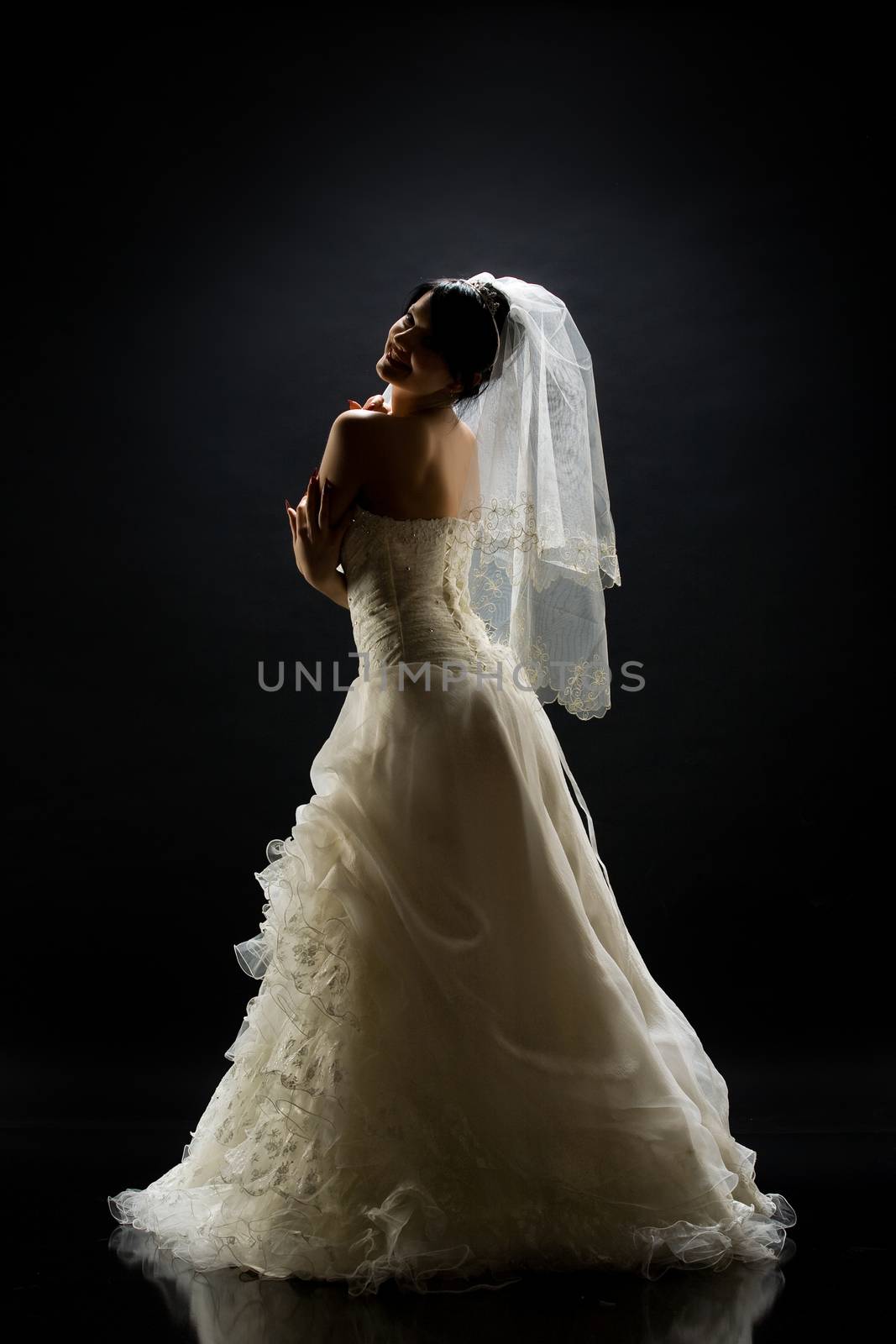 Young beautiful woman in a wedding dress on a studio background