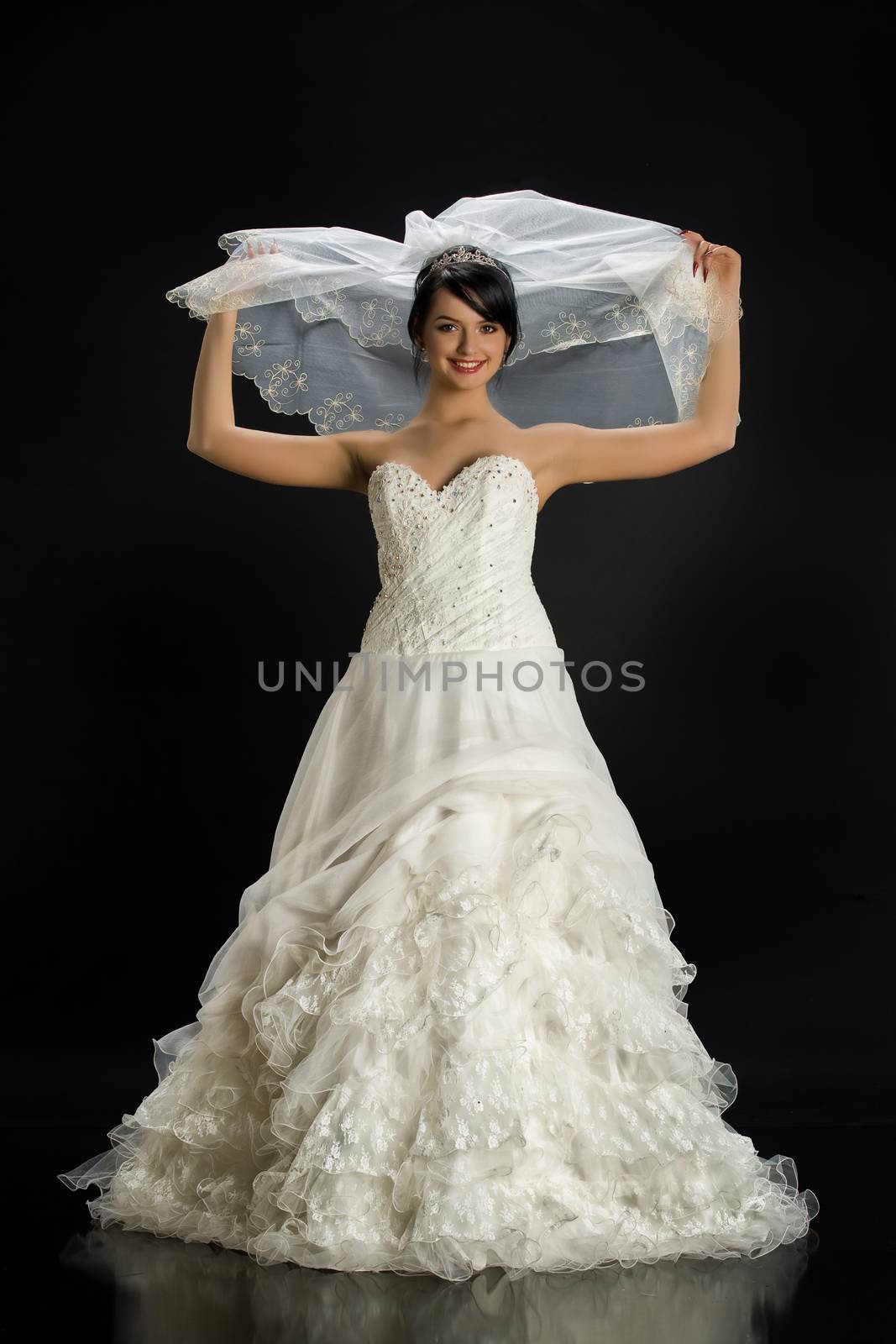 Young beautiful woman in a wedding dress on a studio background