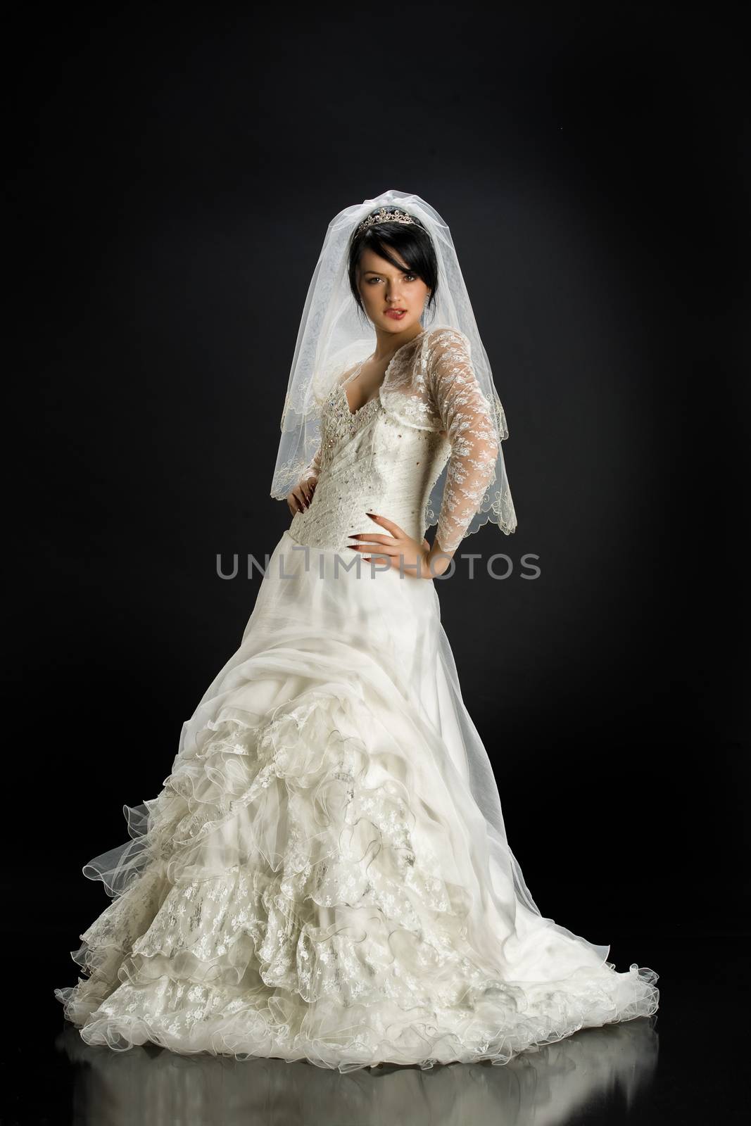Young beautiful woman in a wedding dress on a studio background