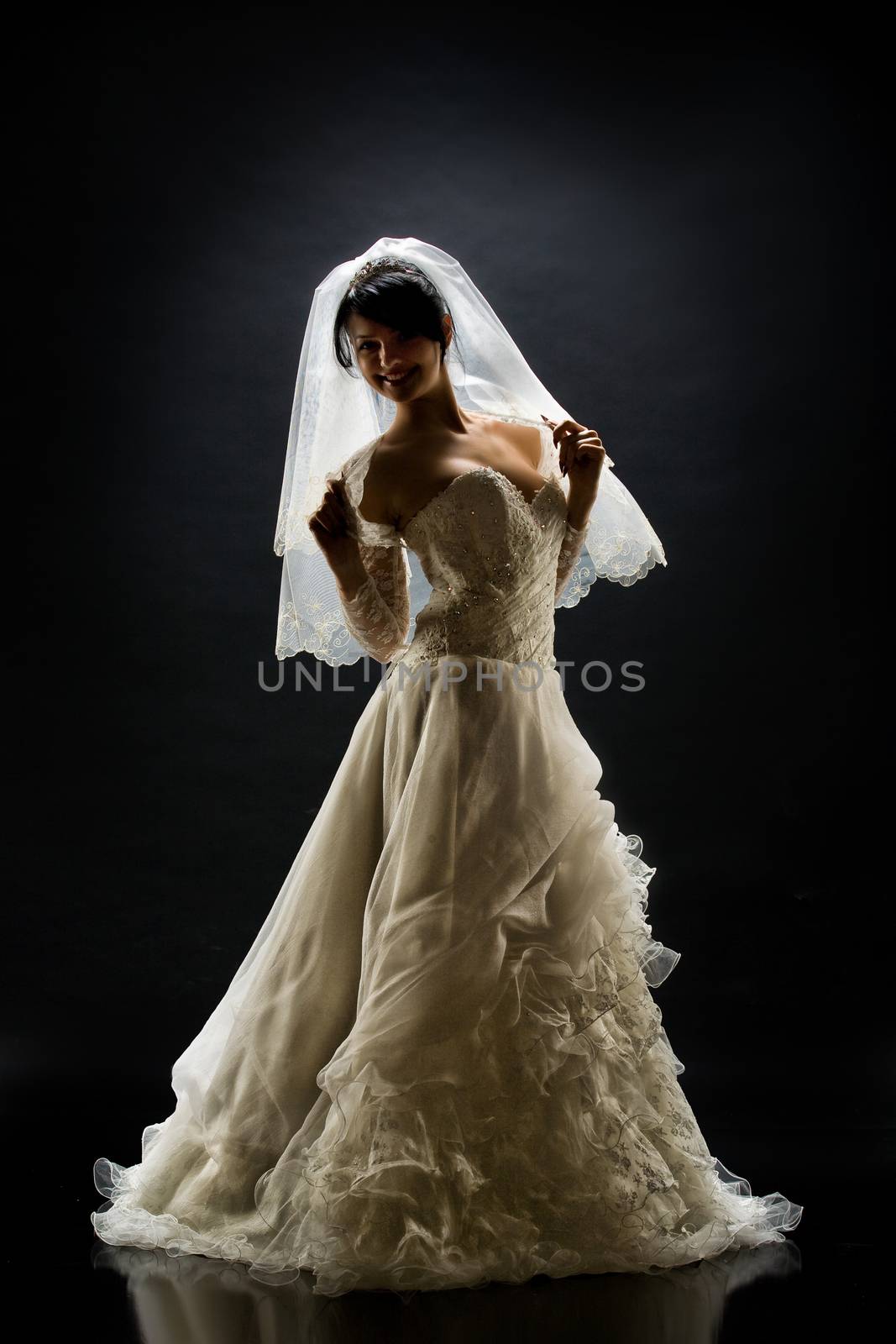 Young beautiful woman in a wedding dress on a studio background