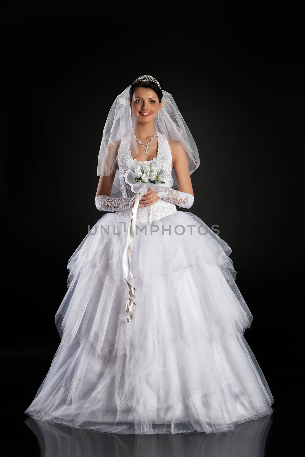 Young beautiful woman in a wedding dress on a studio background