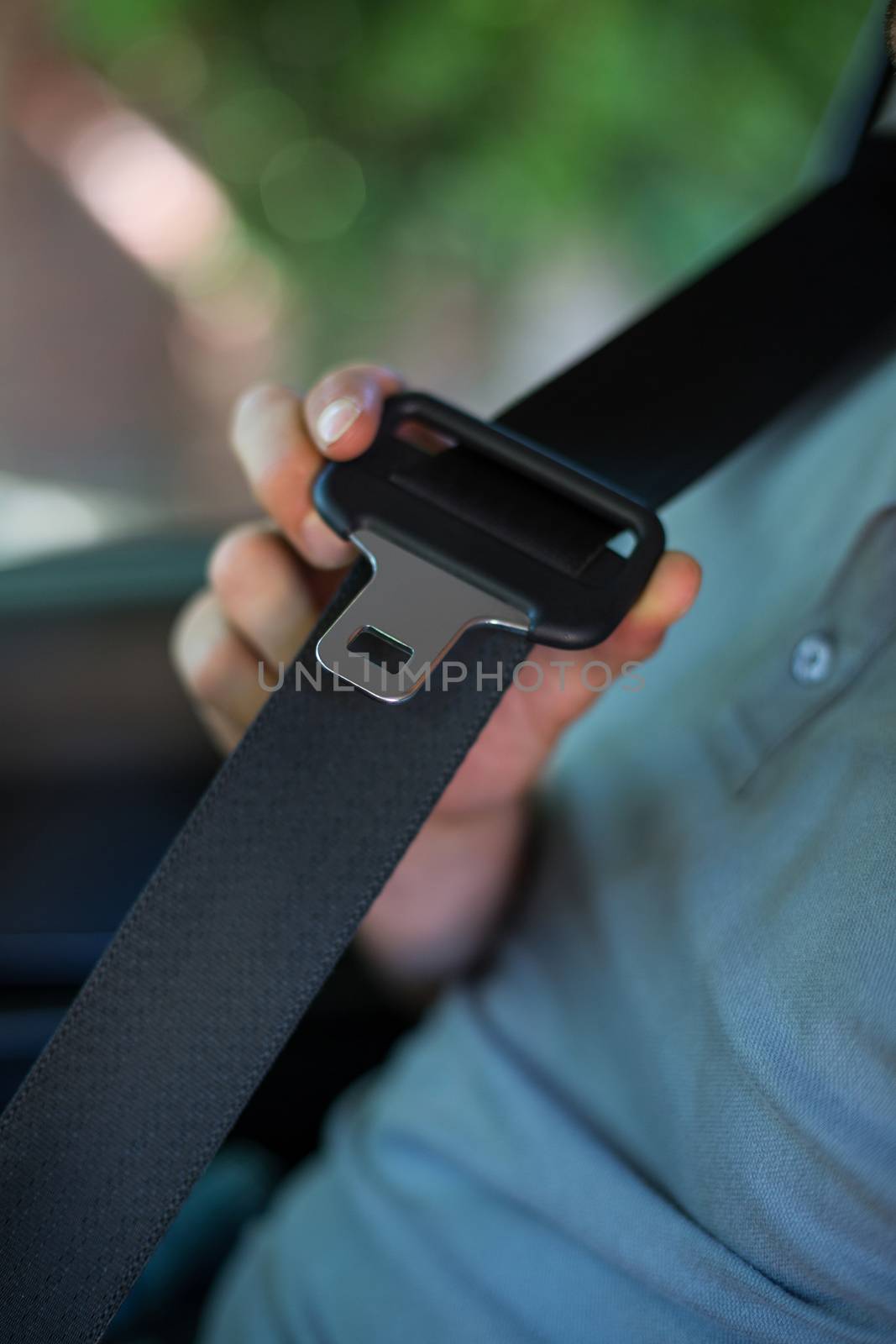 Midsection of driver holding car seat belt