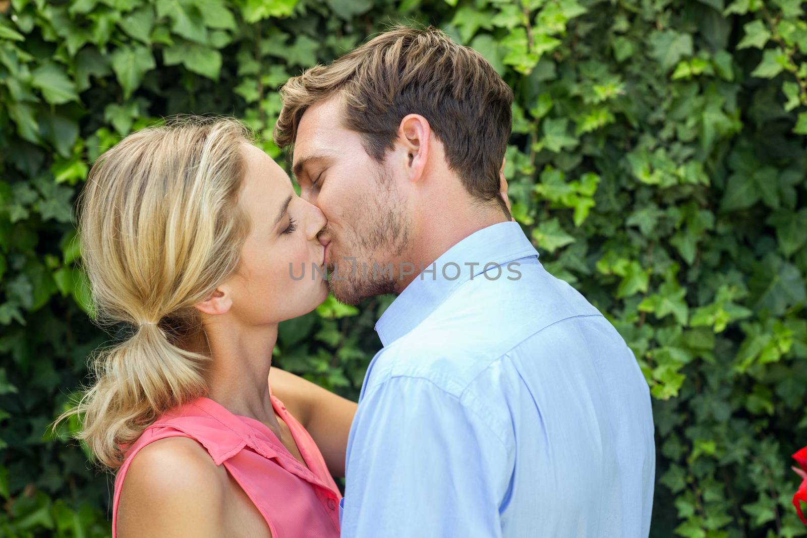 Romantic couple kissing at front yard by Wavebreakmedia