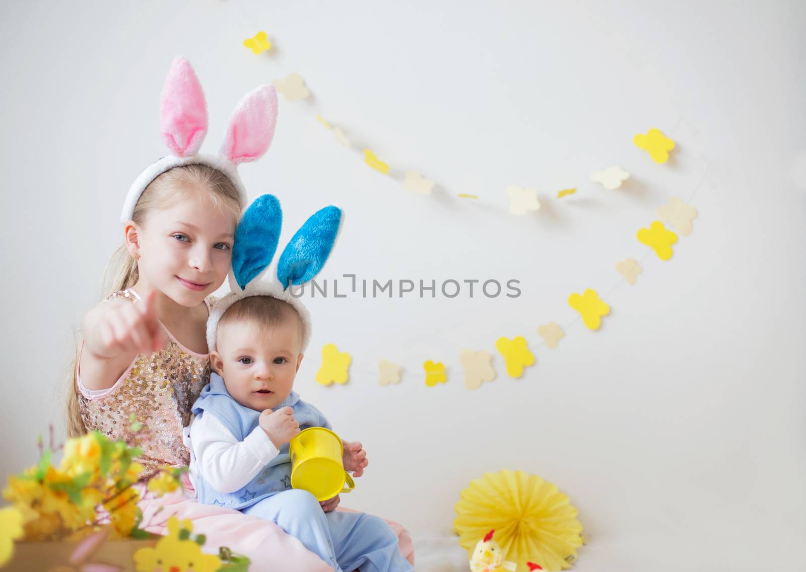 Two cute little children boy and girl wearing bunny ears in Easter decor by Angel_a