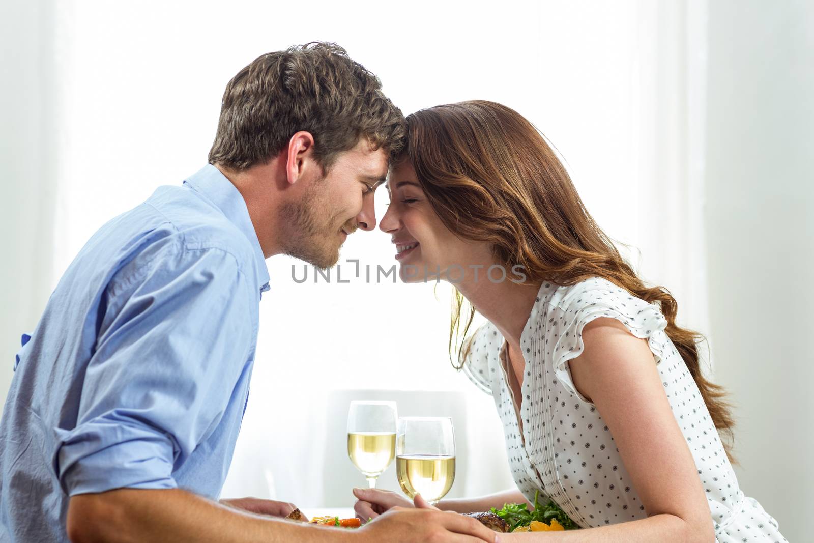 Romantic couple holding wineglasses at home