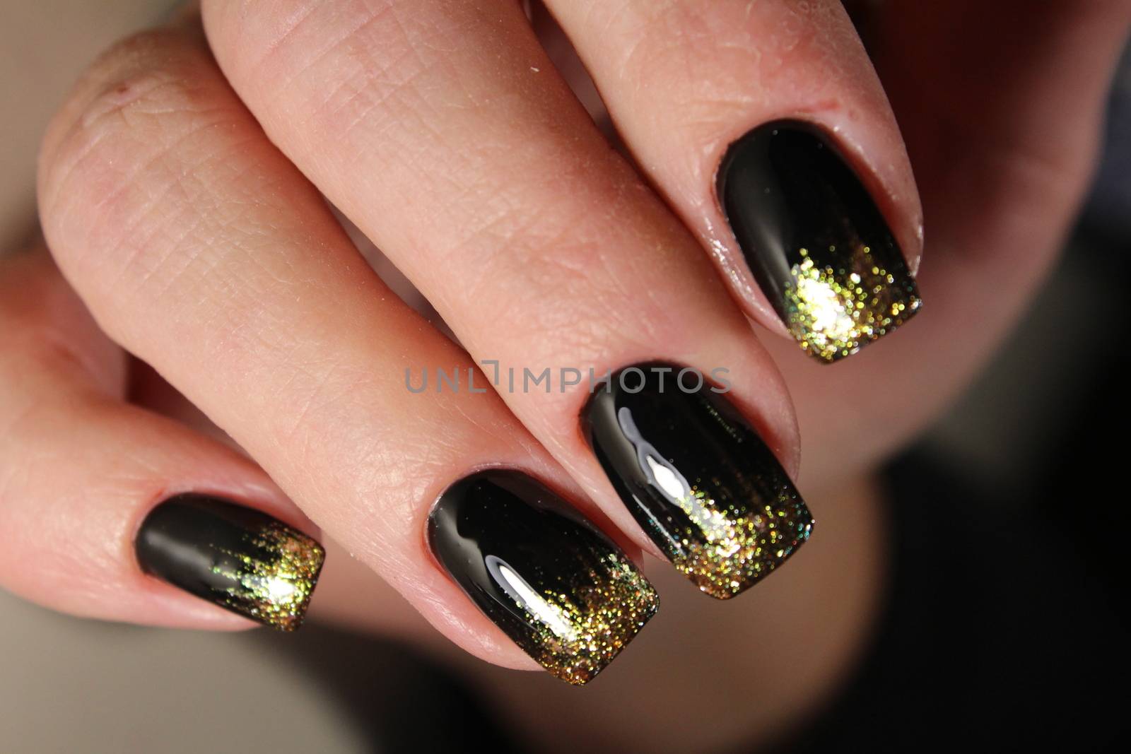 Evening manicure design in black and gold color by SmirMaxStock