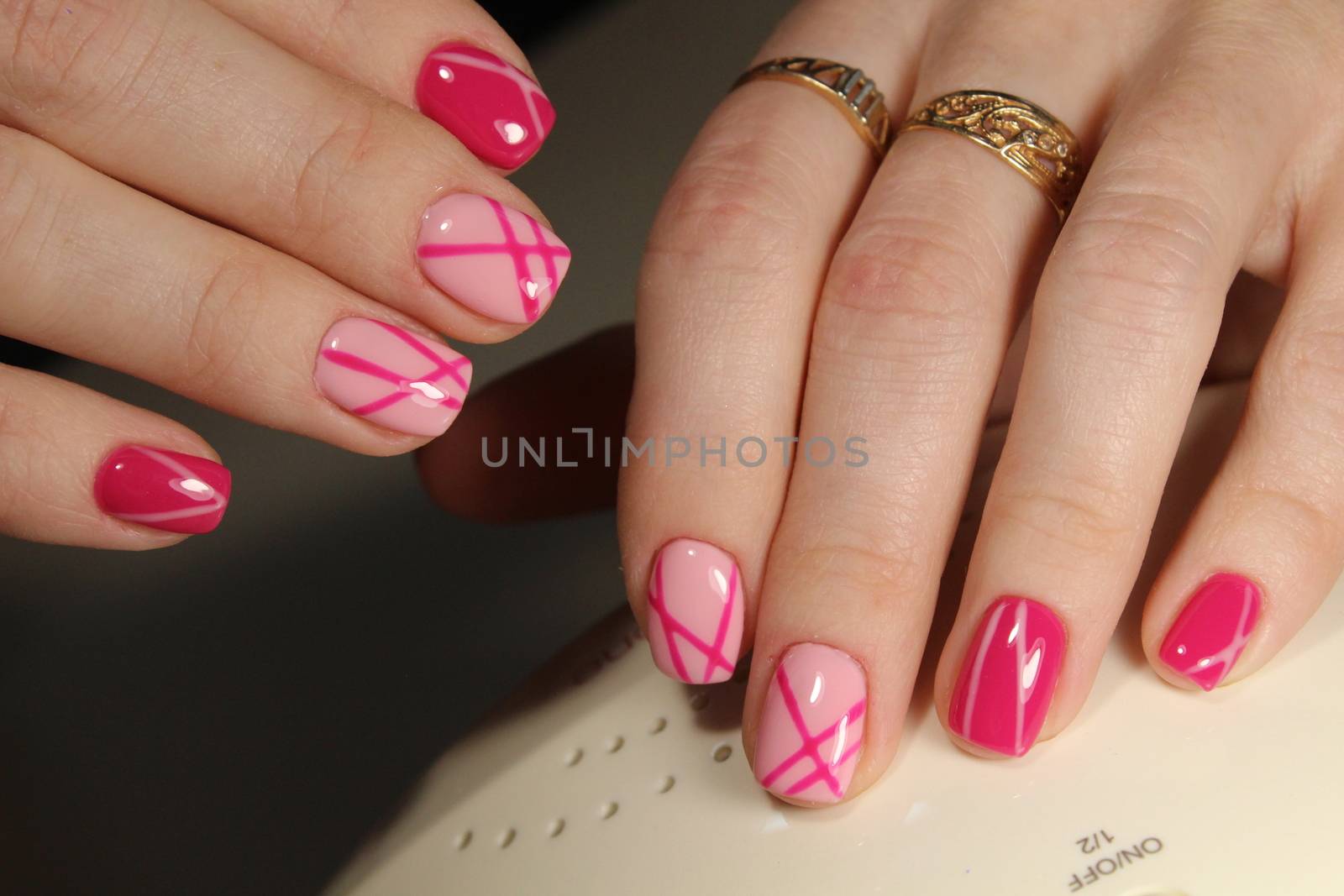 Stylish trendy female manicure. Beautiful young woman's hands on pink