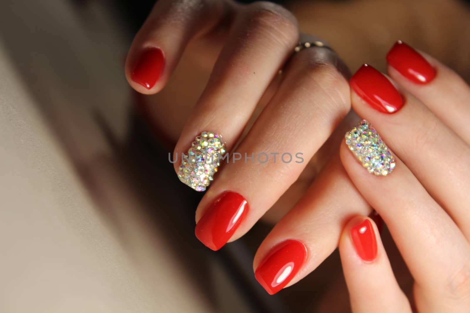 Manicure design is bright red and rhinestones by SmirMaxStock