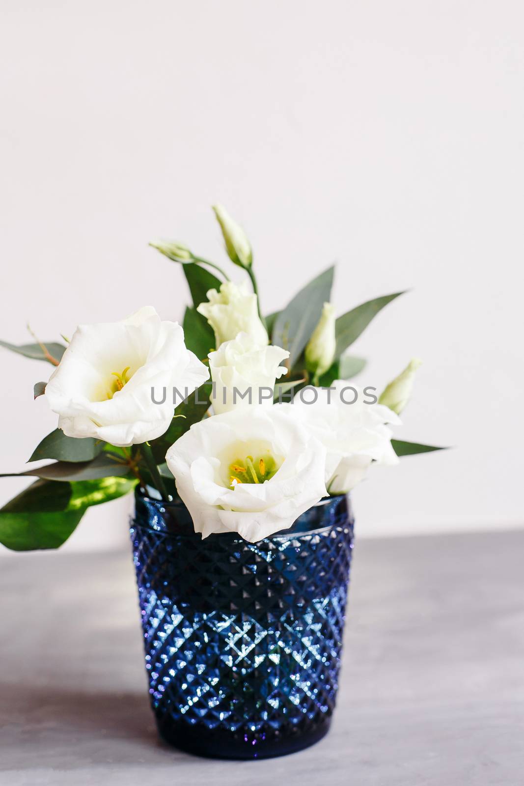 White flowers in classic blue glass. Lisianthus. Eustoma by Denys_N
